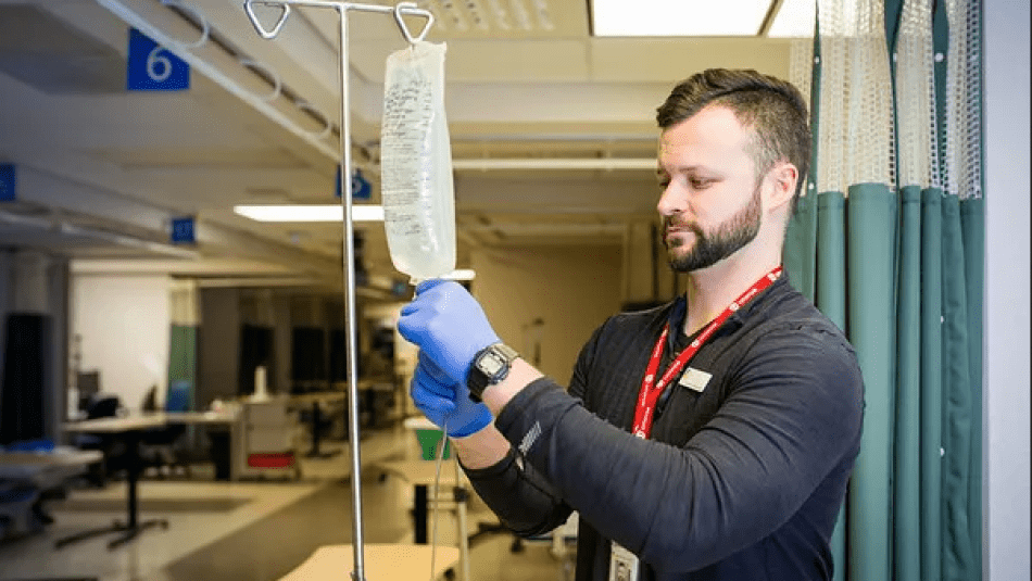 A male nurse checking on a IV bag