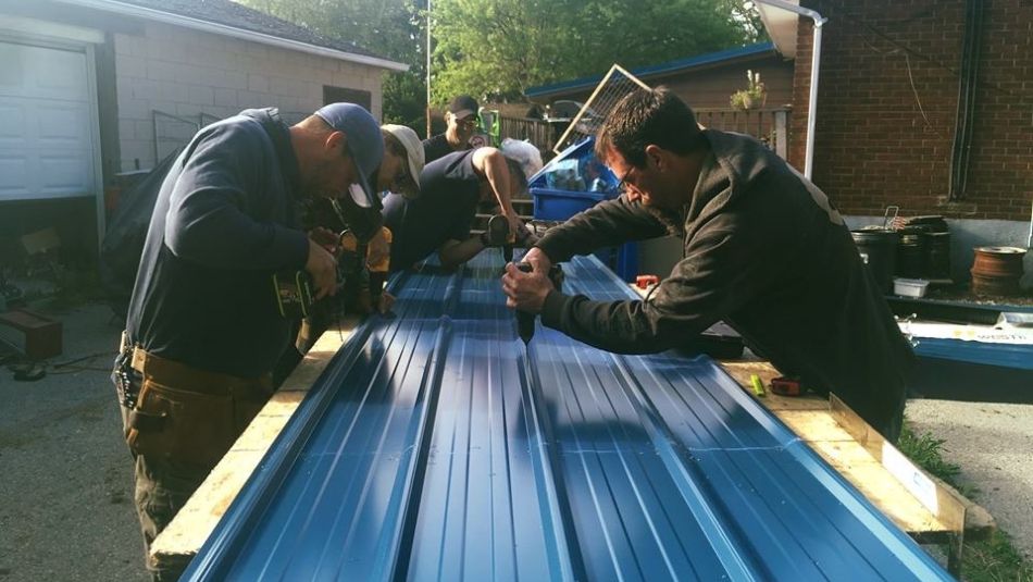 Members of Local 16-O work on a piece of aluminum roofing.