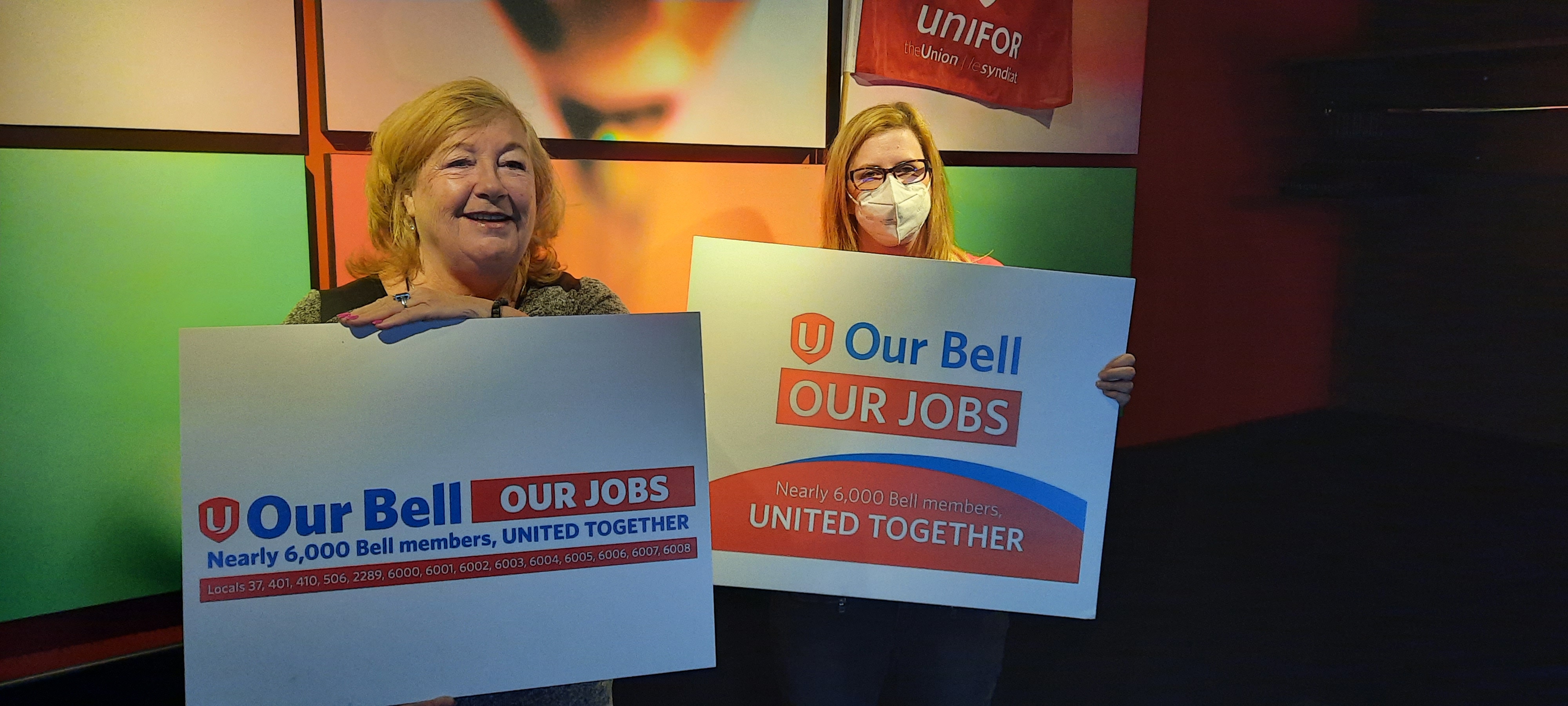 French  Les membres de Bell posent avec une pancarte indiquant « Notre cloche, nos emplois »
