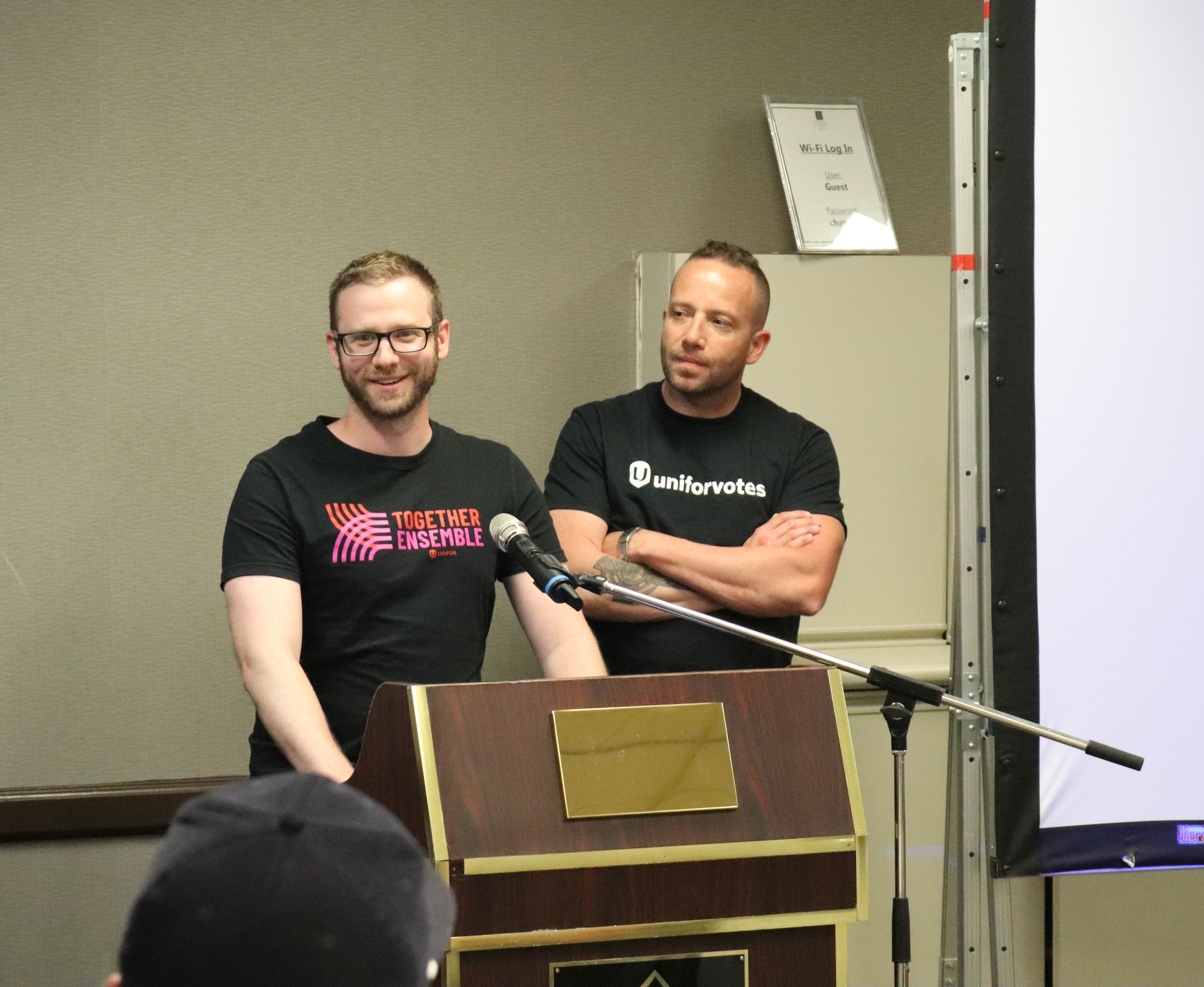 two men standing at a podium 