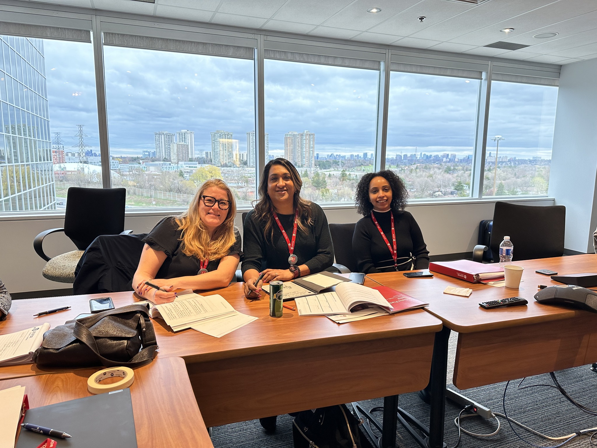 Three women sitting behind a table smiling 