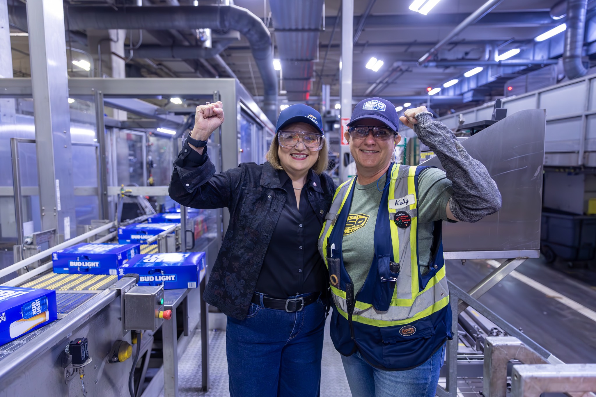La présidente nationale Lana Payne pose avec un employé de la brasserie Labett, le poing levé.