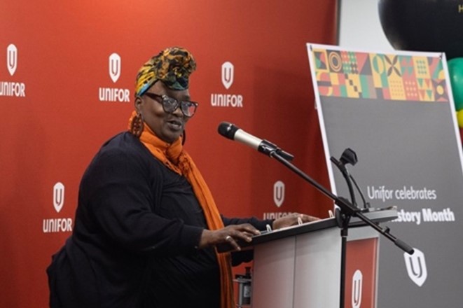 A women speaks at a mic.