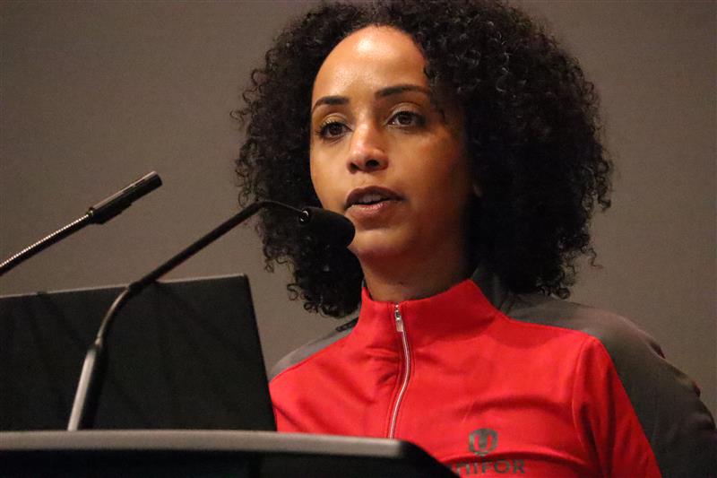 A women speaks at a mic.