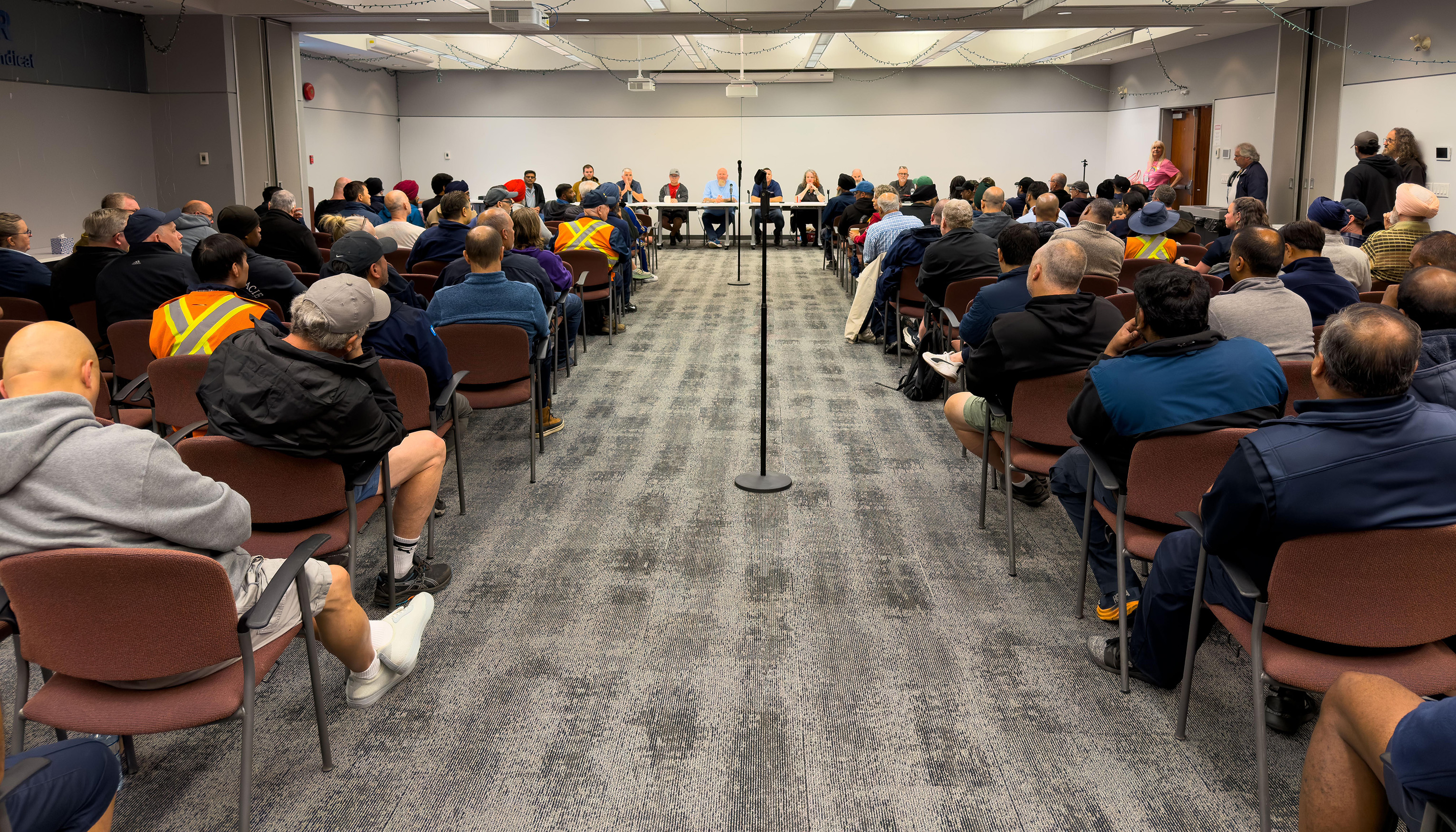 A photo from the back of a room full of people sitting listening attentively