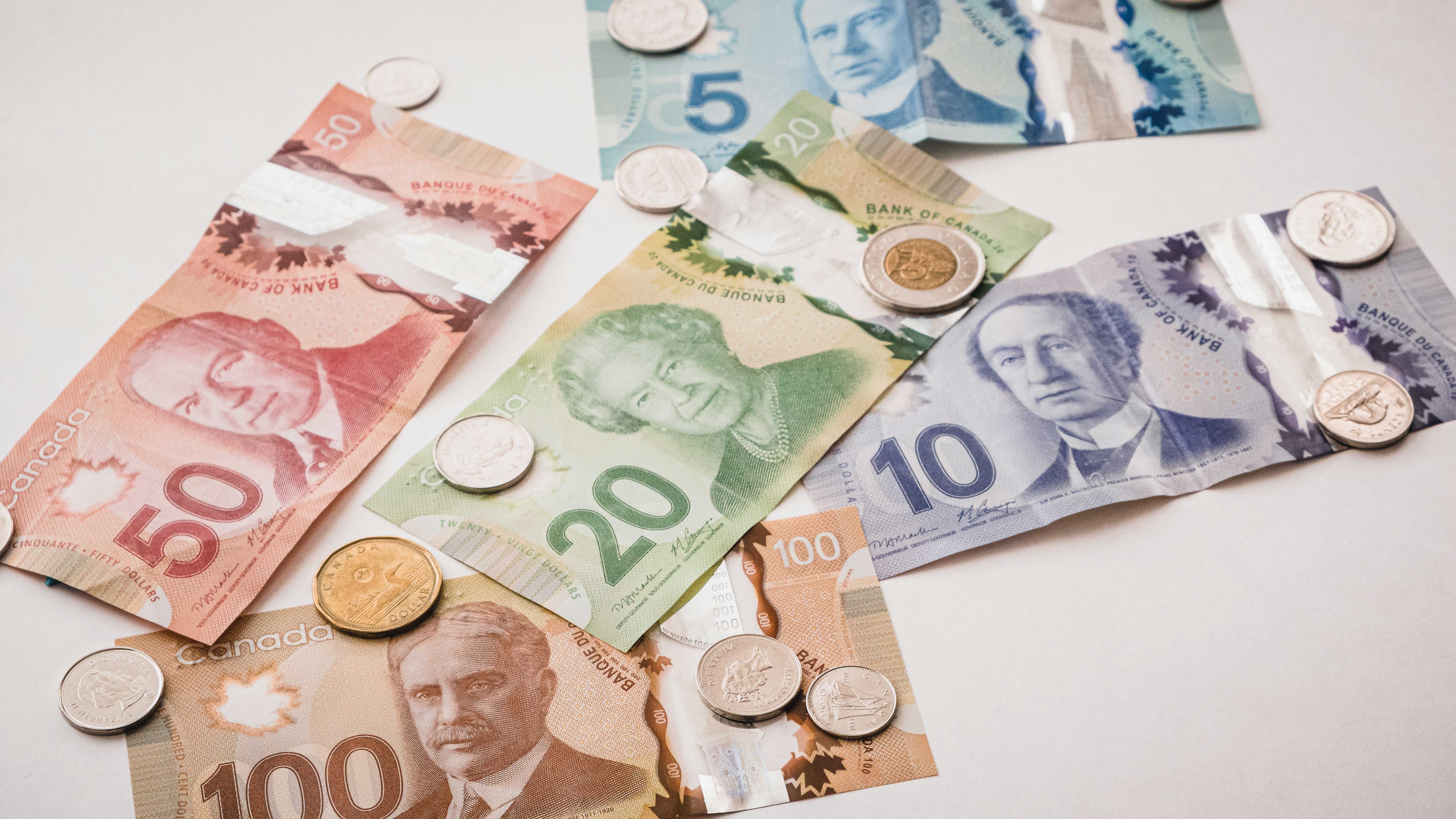 Canadian money bills spread out on a surface.