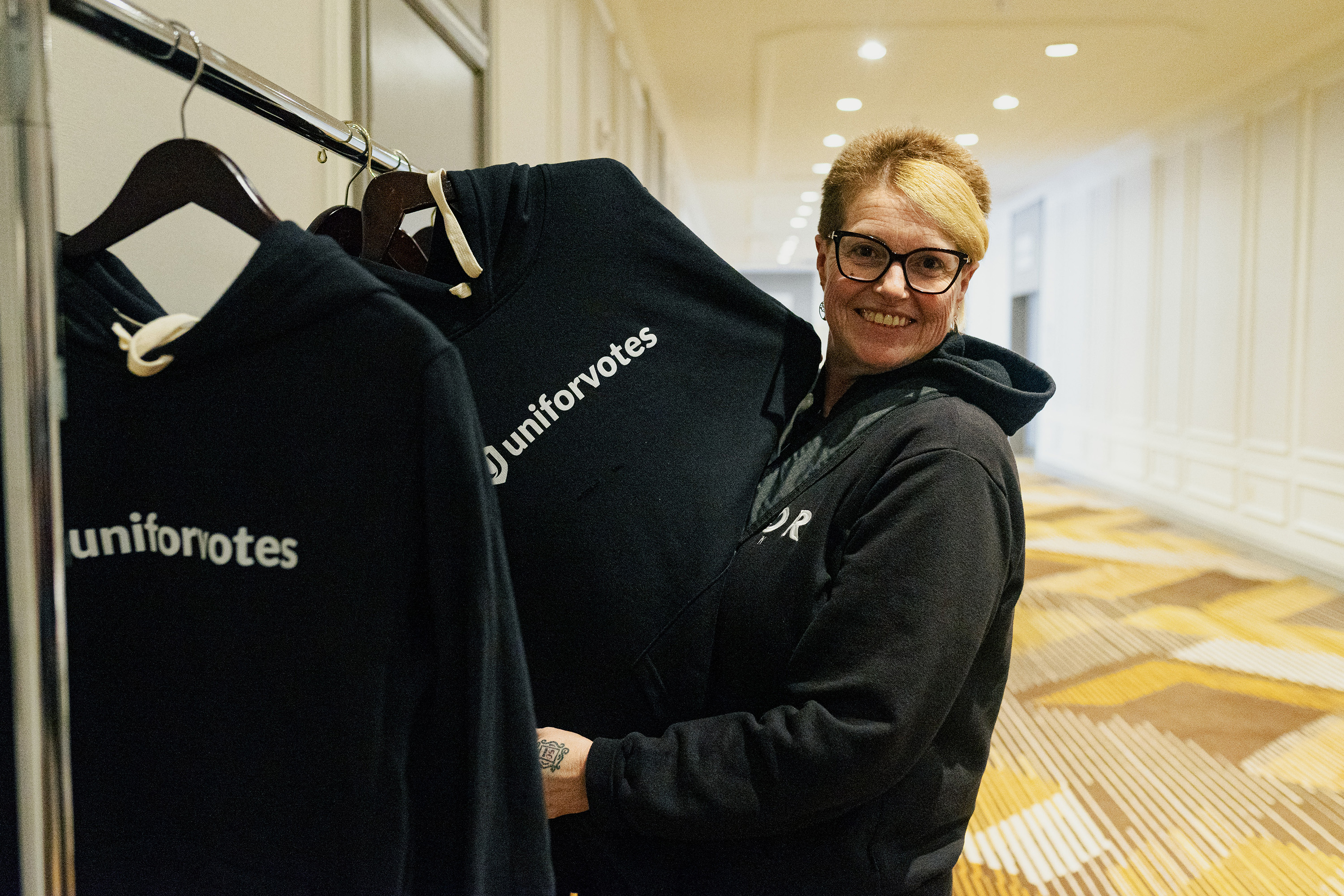 A women holding up a Unifor votes hooding from a coatrack