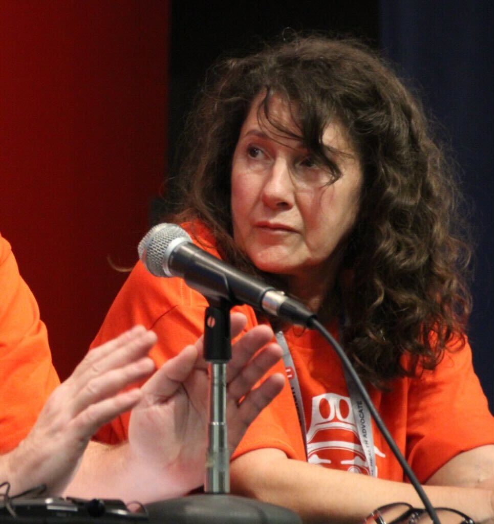 Della Rogers seated behind a microphone.