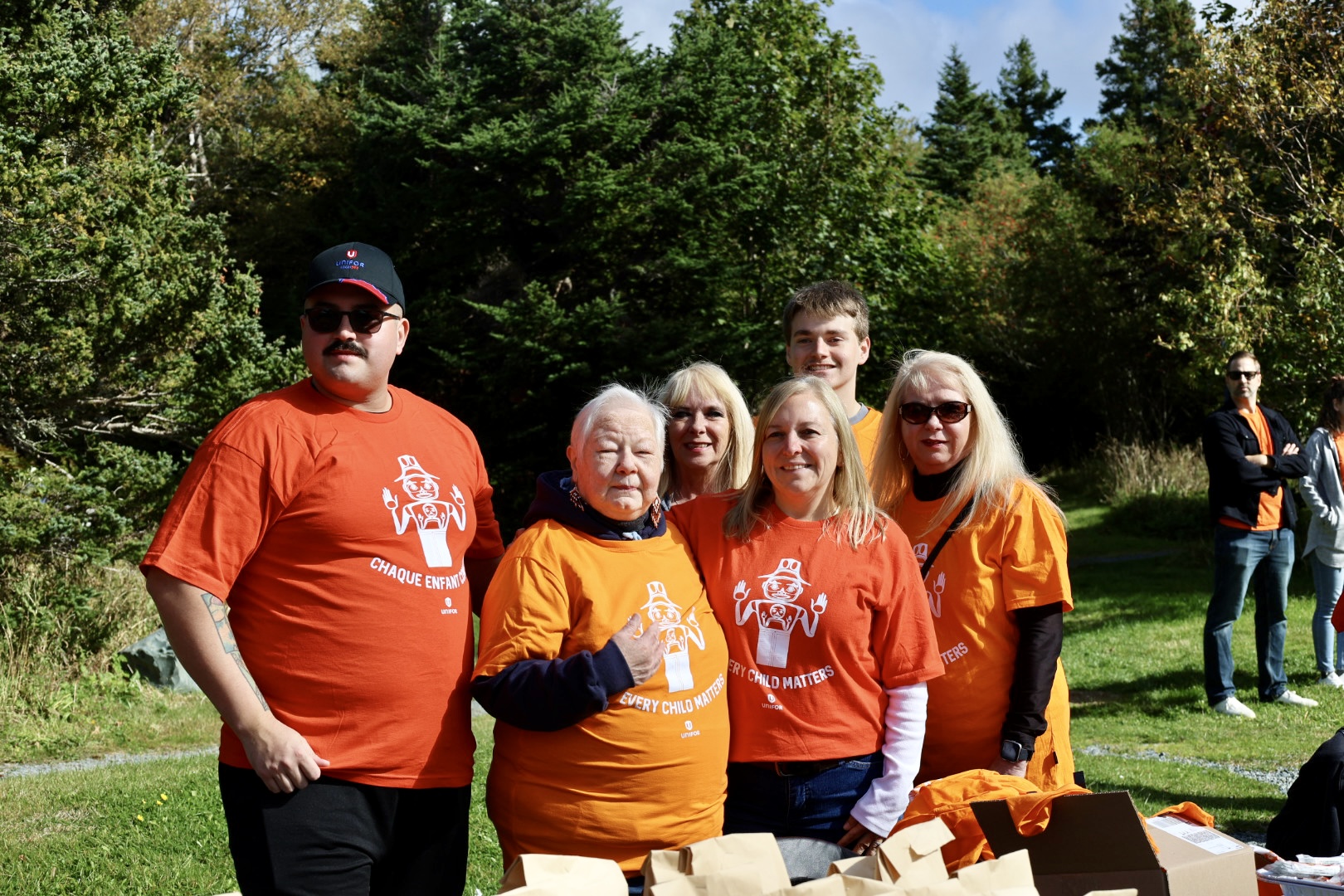 five people outside in orange shirts