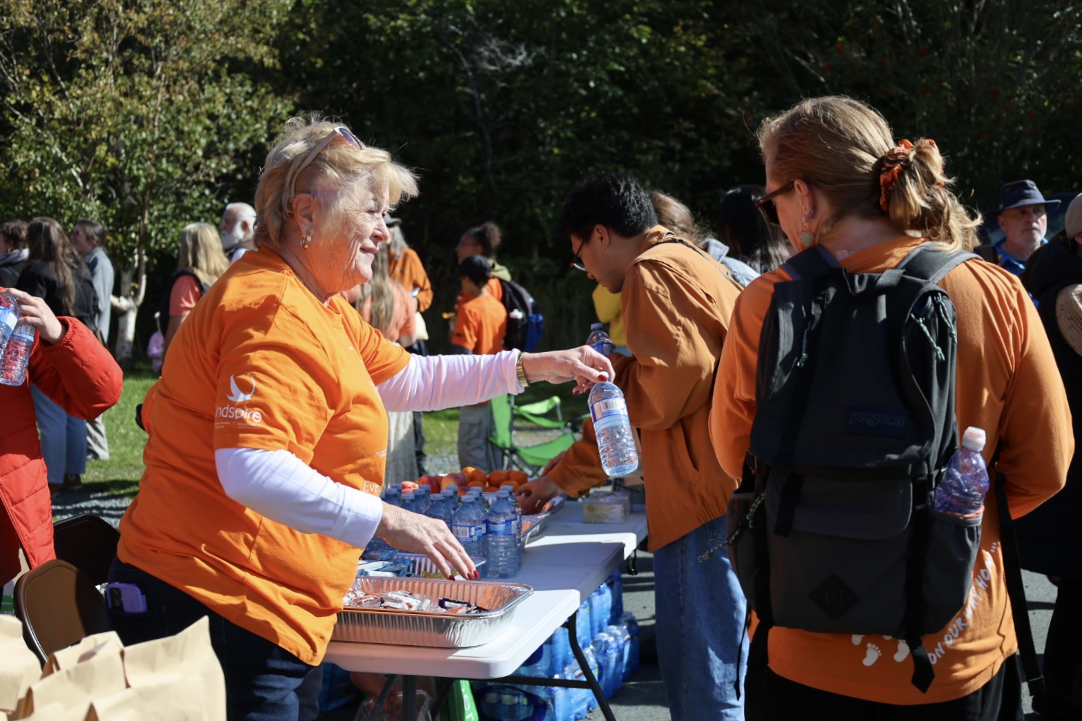 A women hands out a water bottle