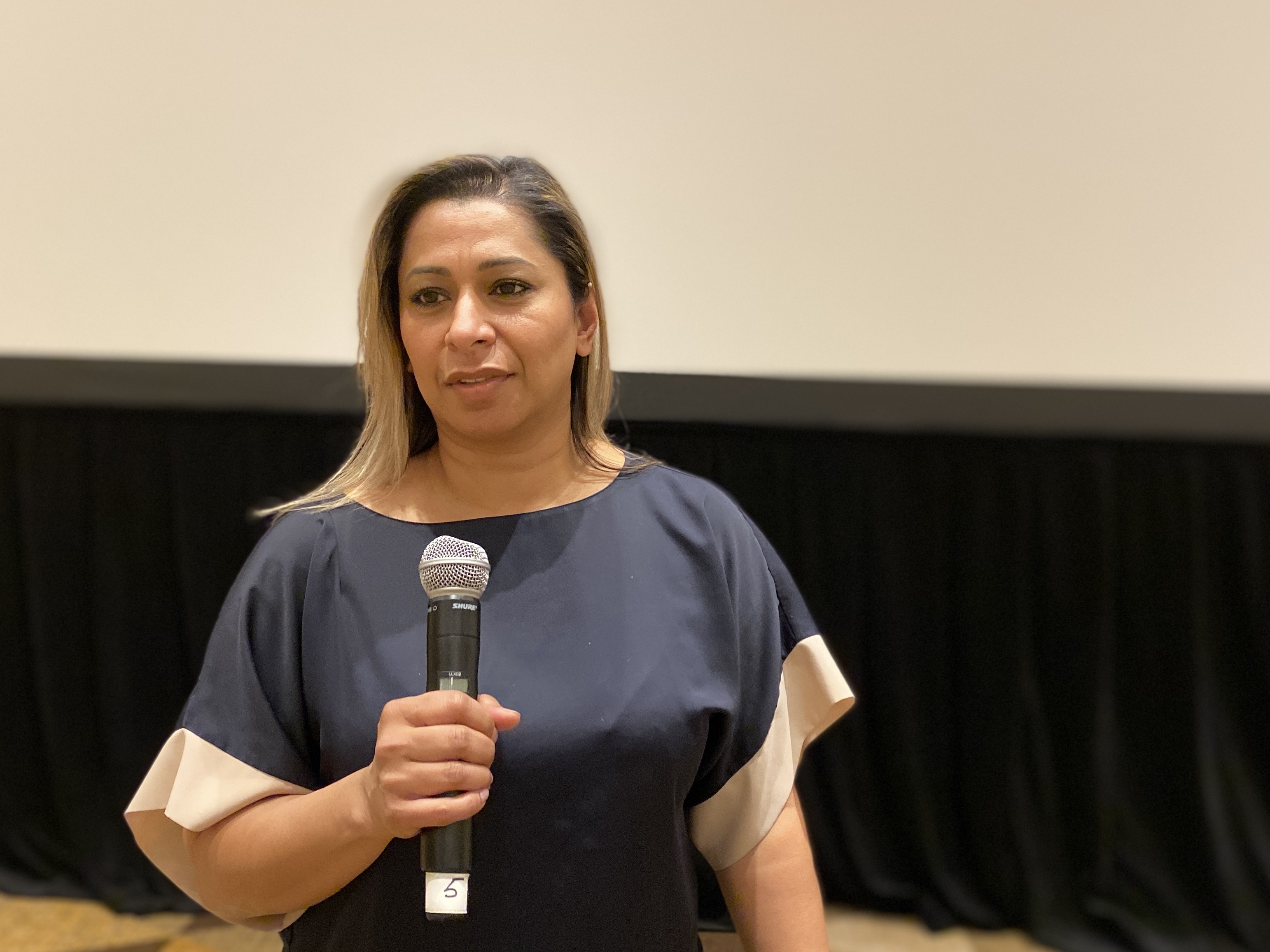 Unifor Ontario regional Director Naureen Rizvi speaks at a microphone 