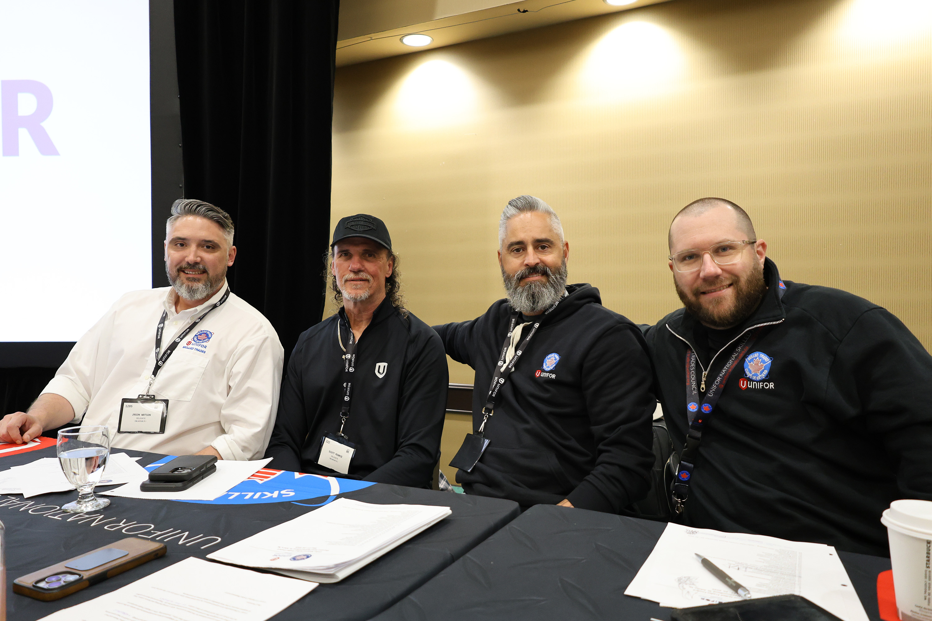 four men sitting behind a table