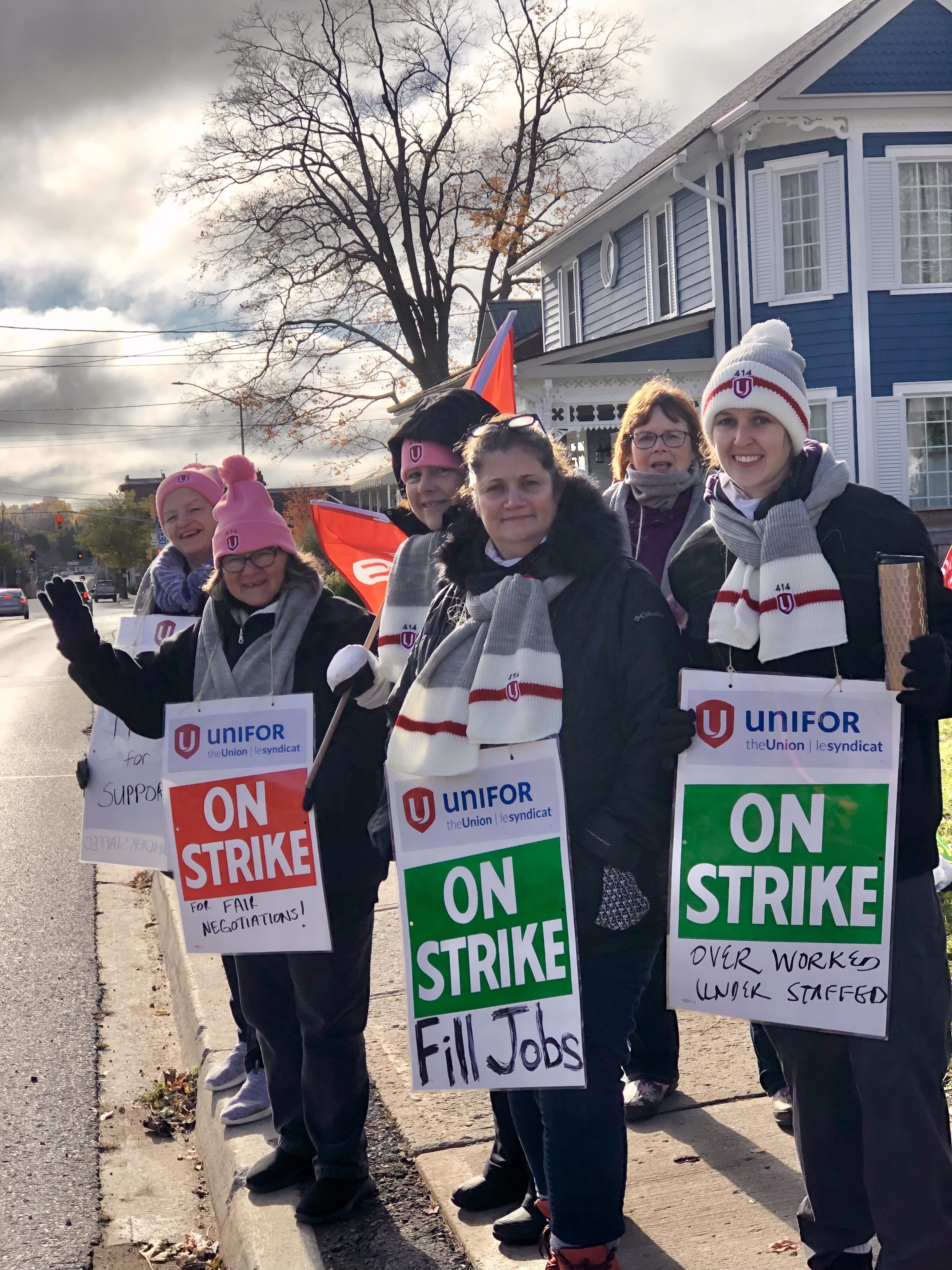 Striking women’s shelter workers smile on the picket line.