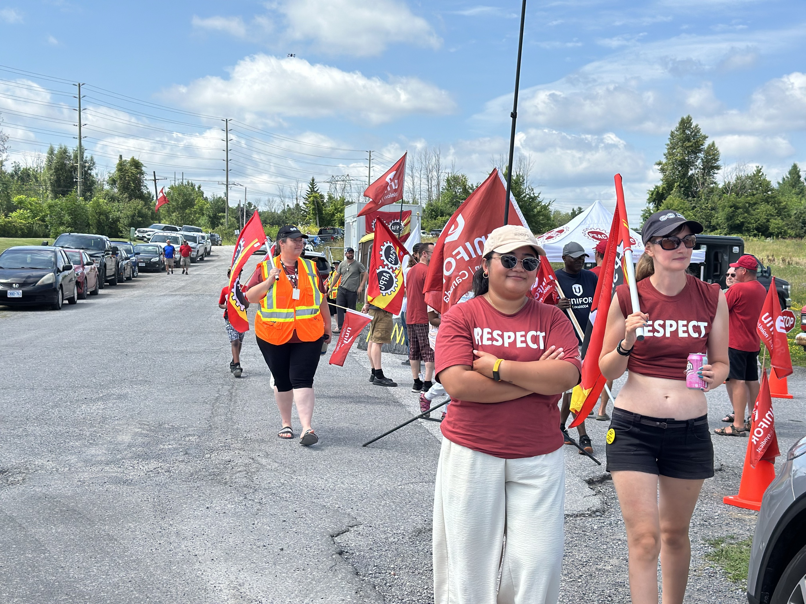 People wearing red respect teeshirts walking on street with red flags