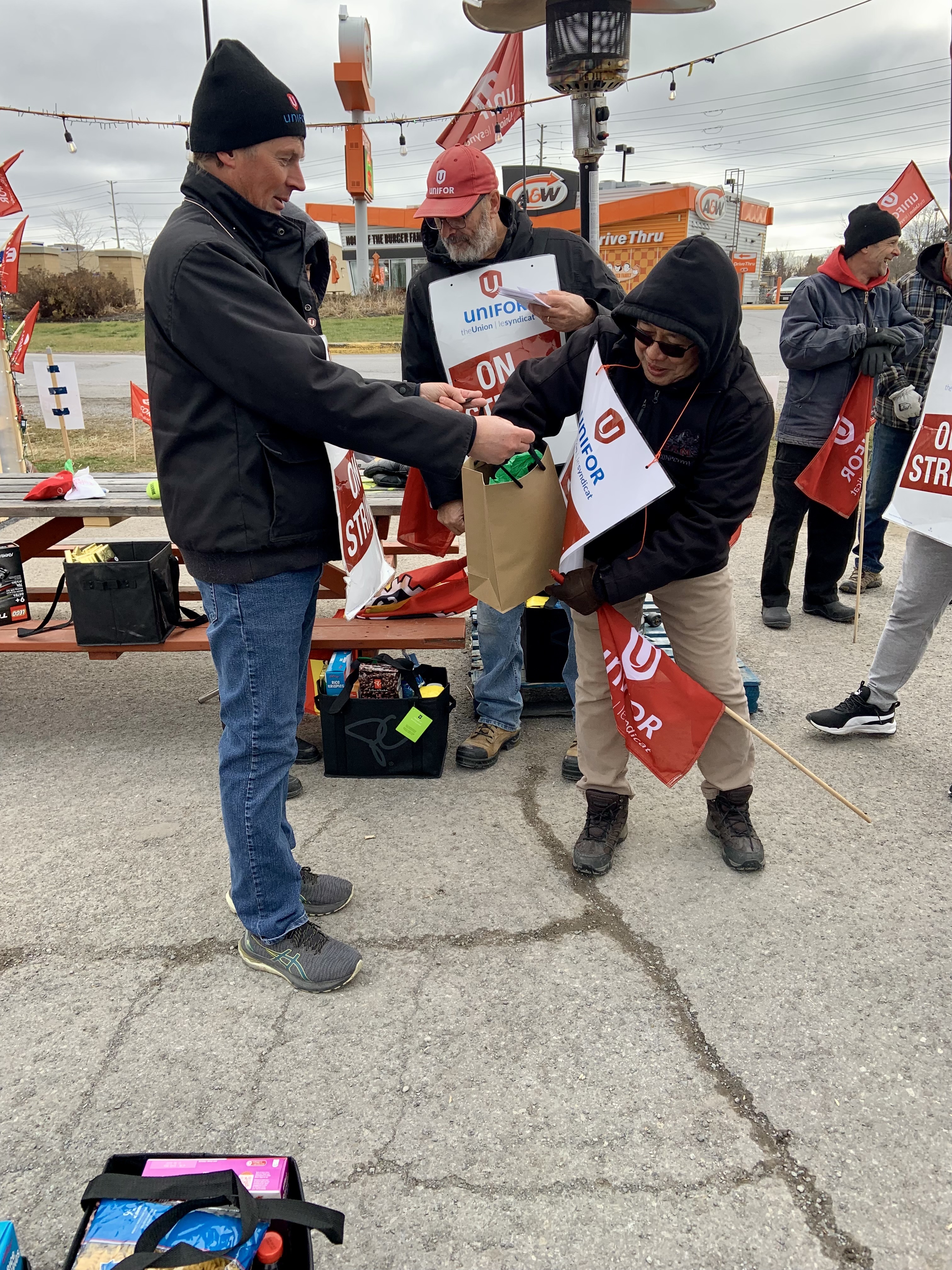 A volunteer hands out gift bags to striking workers