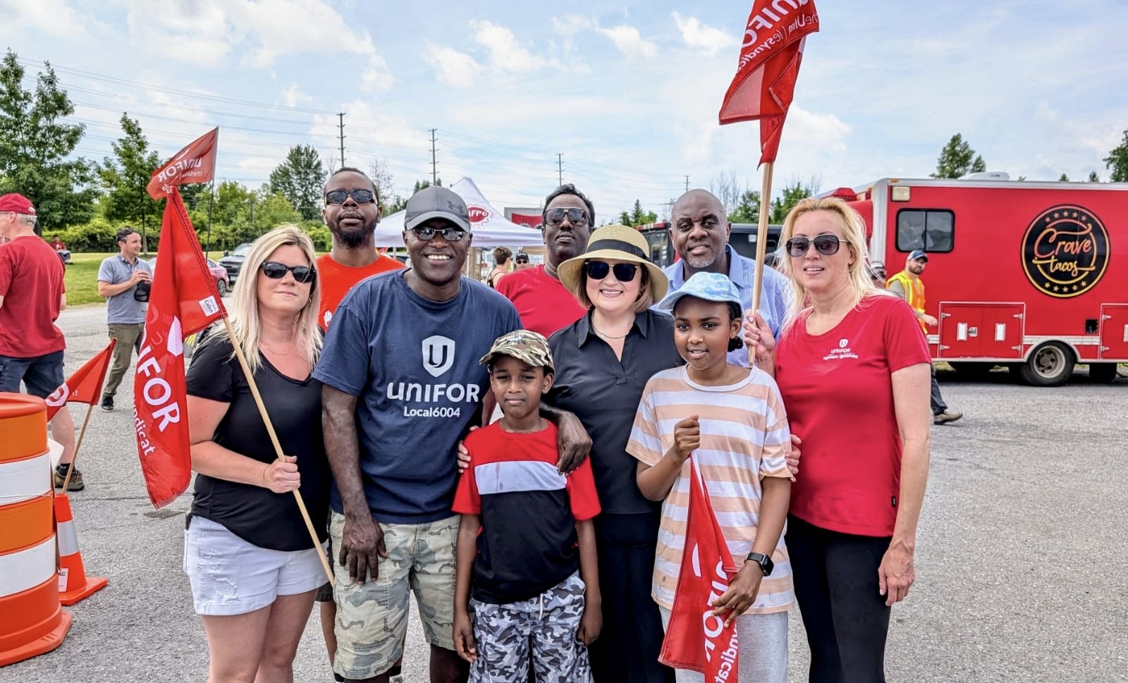 group photo with red flags and red truck in background
