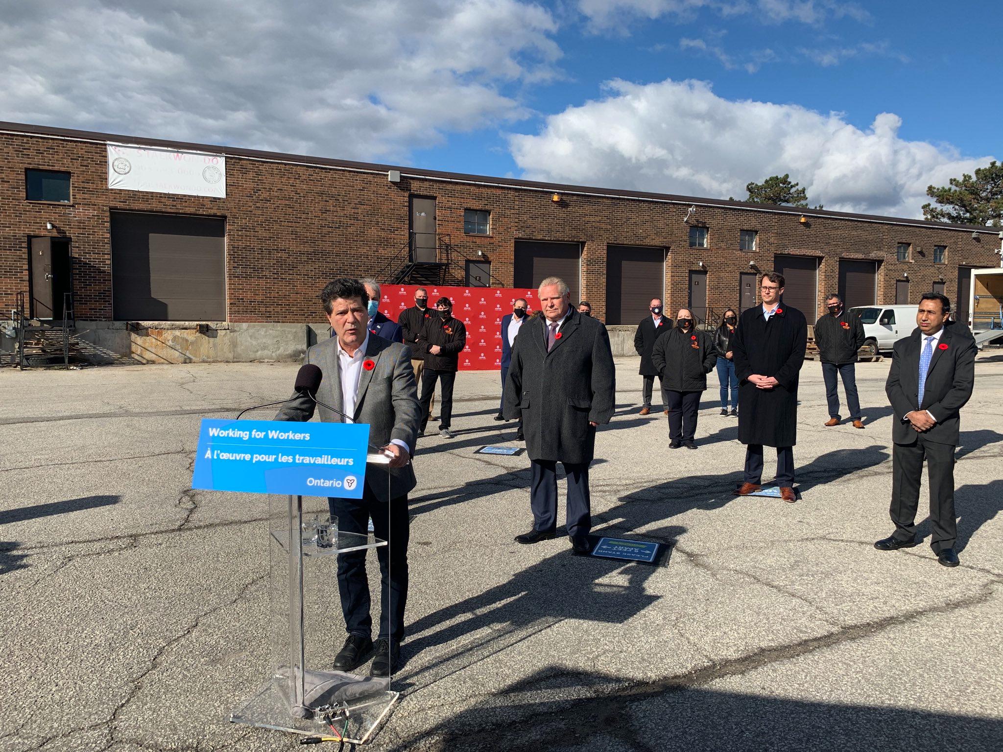 Jerry Dias stands at a podium outdoors at minimum wage announcement.