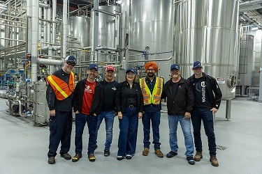 A group of people pose for photo at beer brewery.