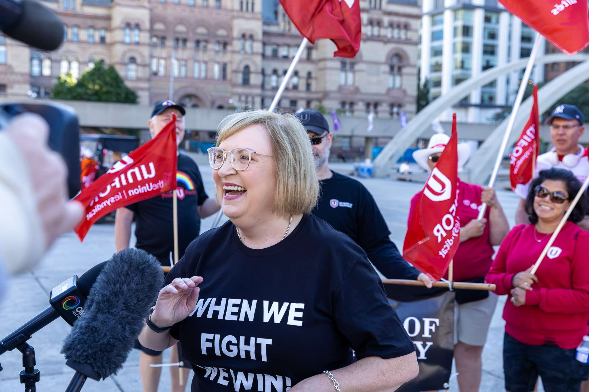 A woman standing in front of microphones