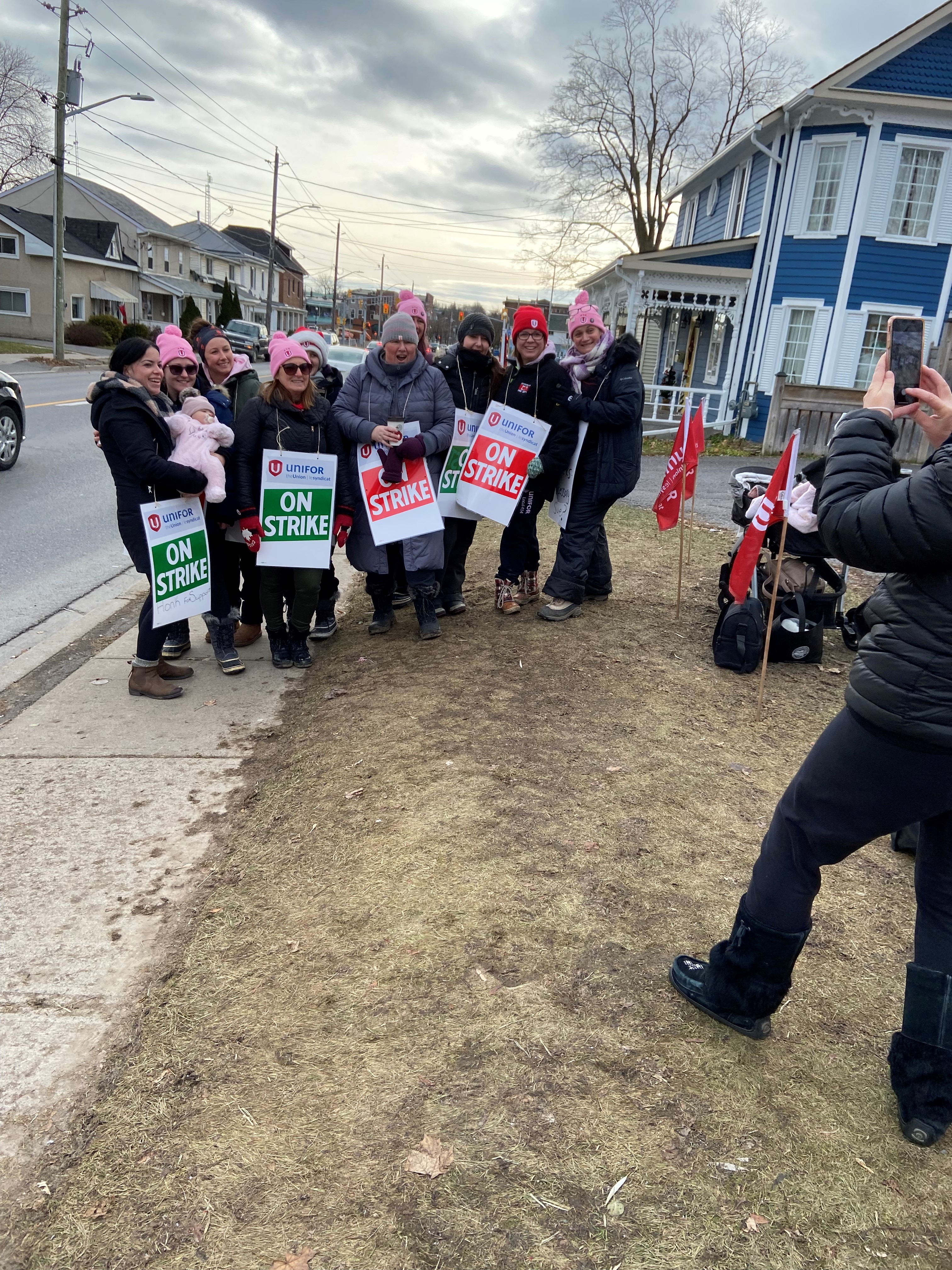 Women holding picket signs smiling