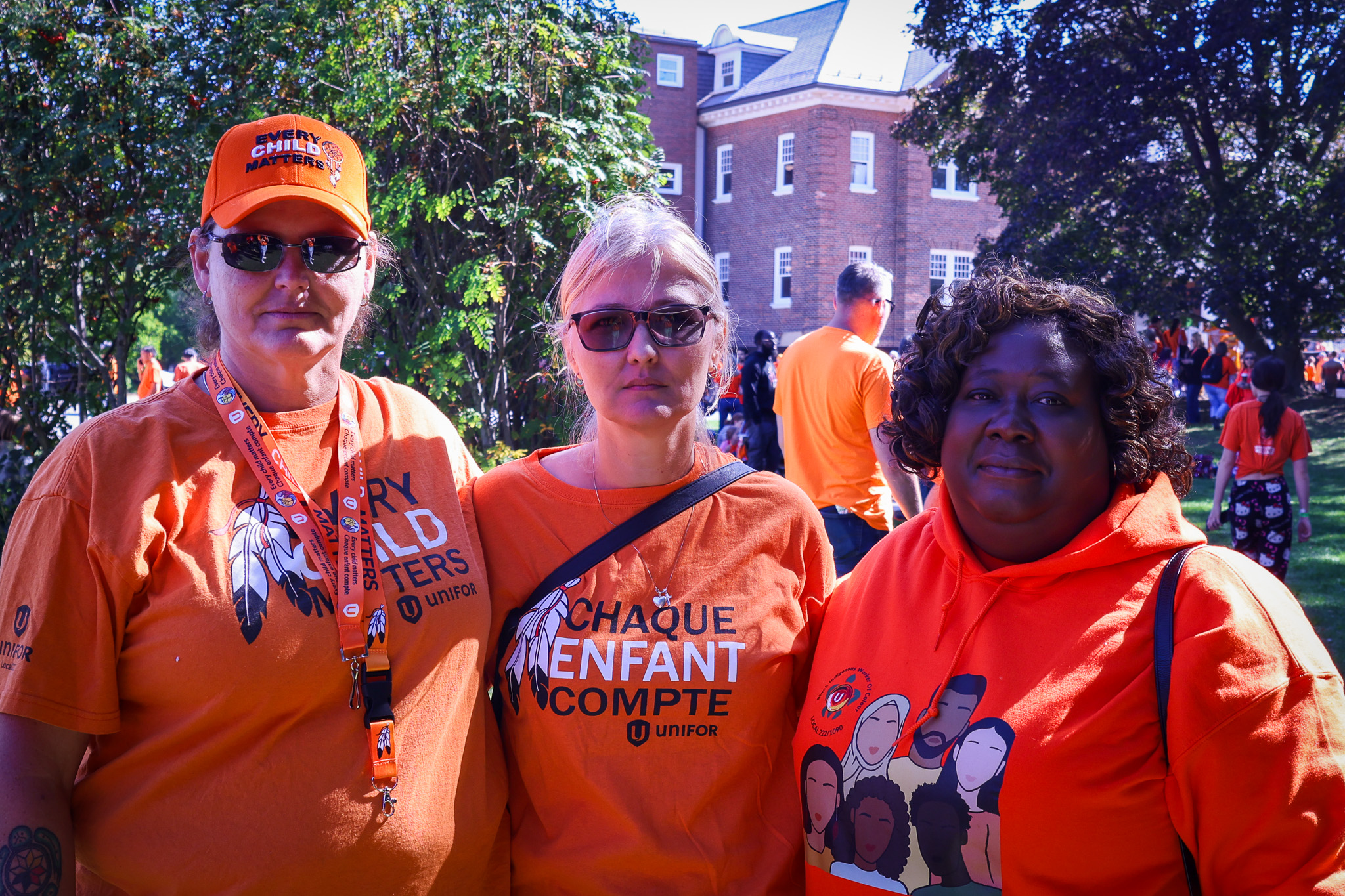 Three people wearing orange shirts