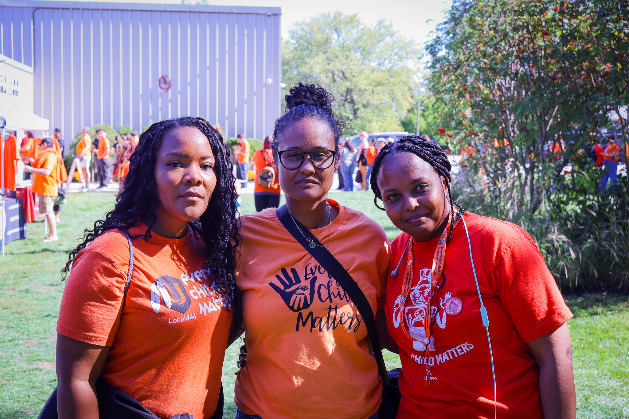 Three people in orange shirts