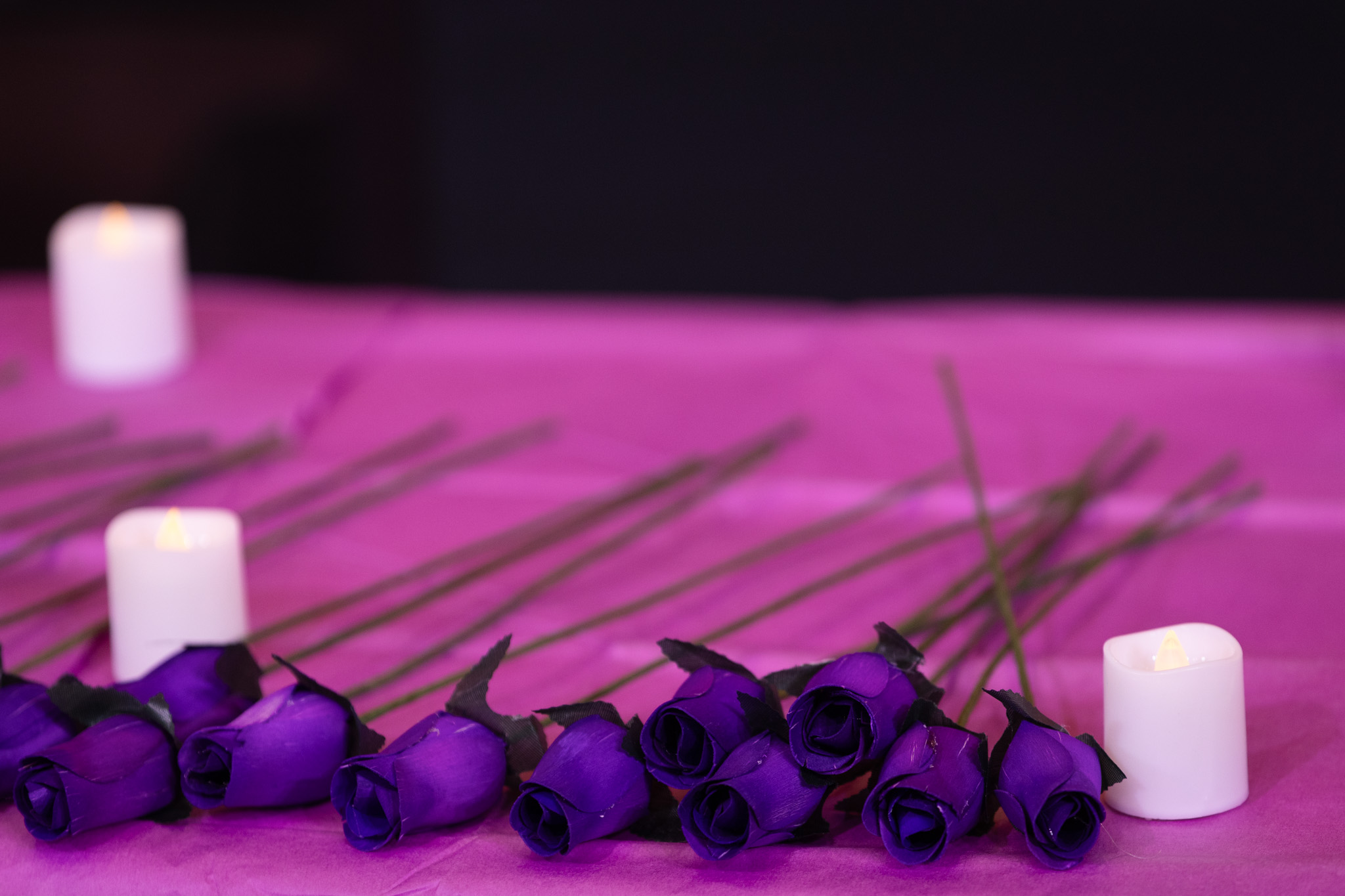 purple flowers laying on a table with candles
