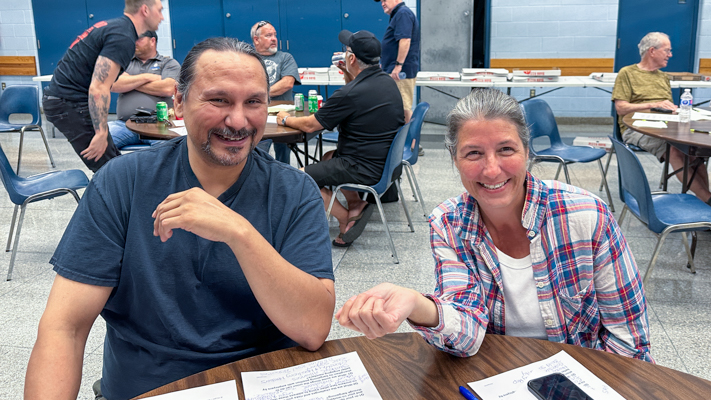 Two seated people smiling