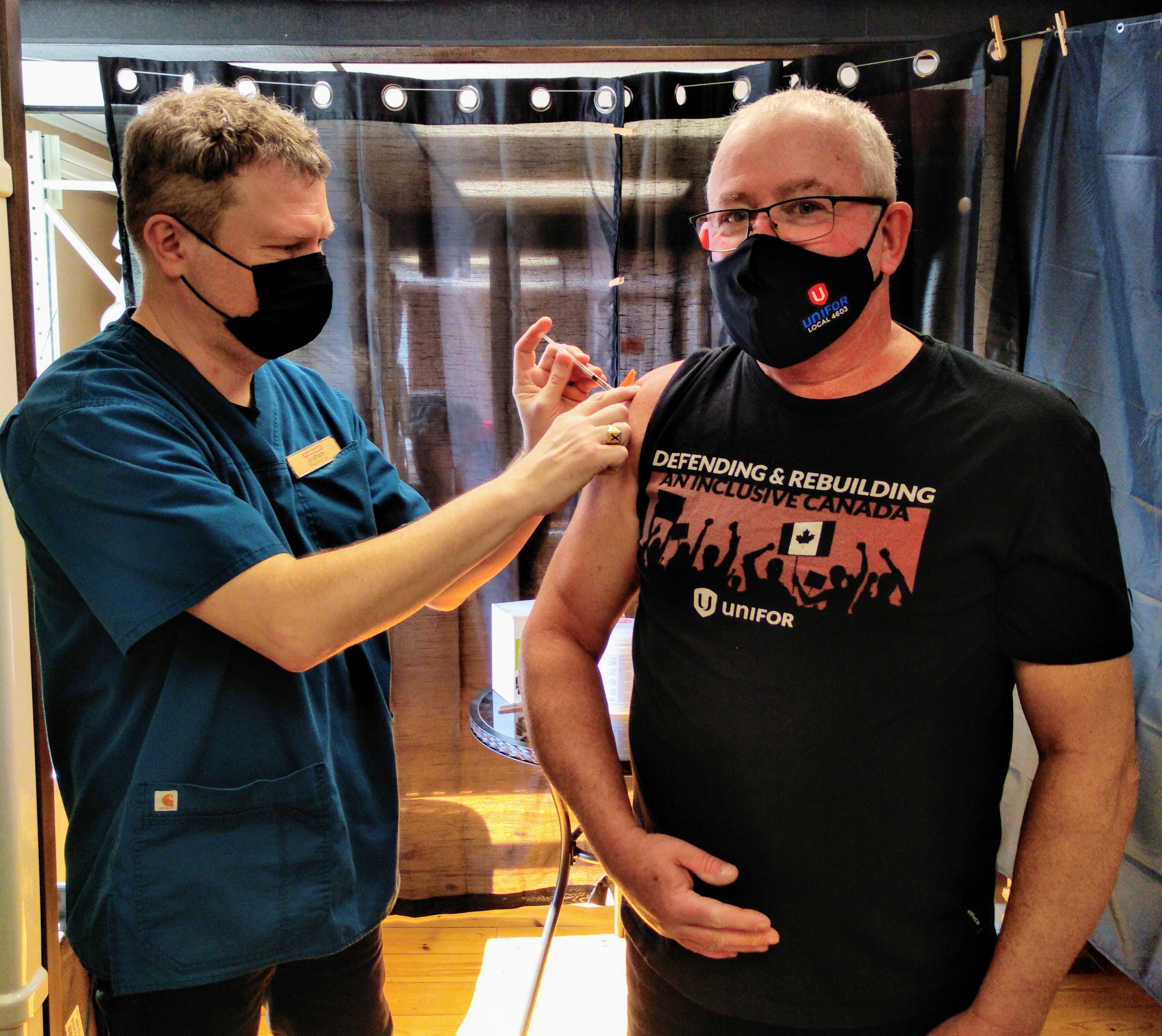 A Unifor member receives their COVID vaccine from a health care worker.