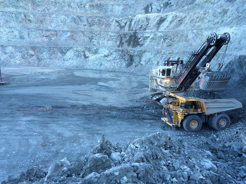 Digger chargeant du minerai dans un camion jaune