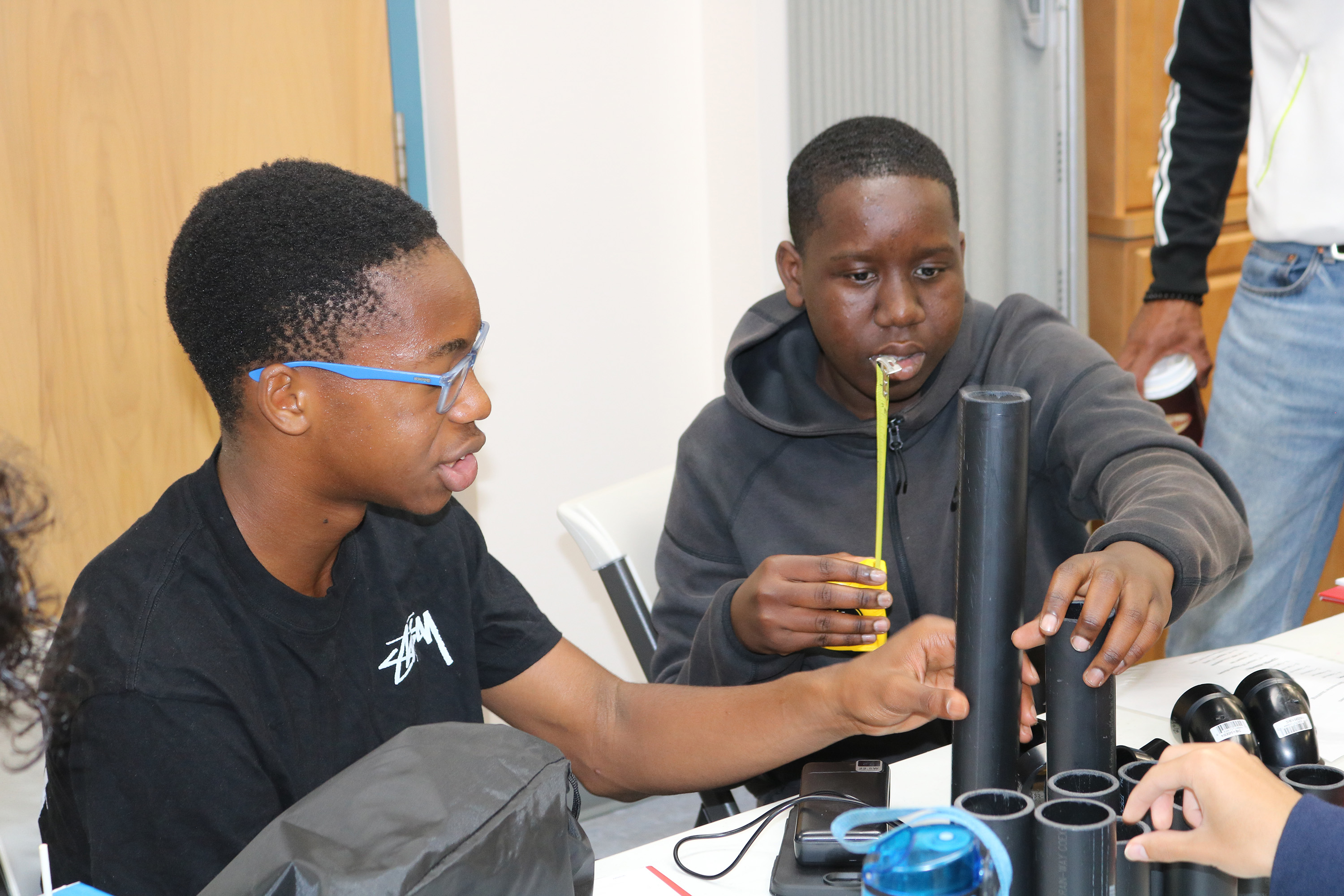 Two students working on a pipe structure