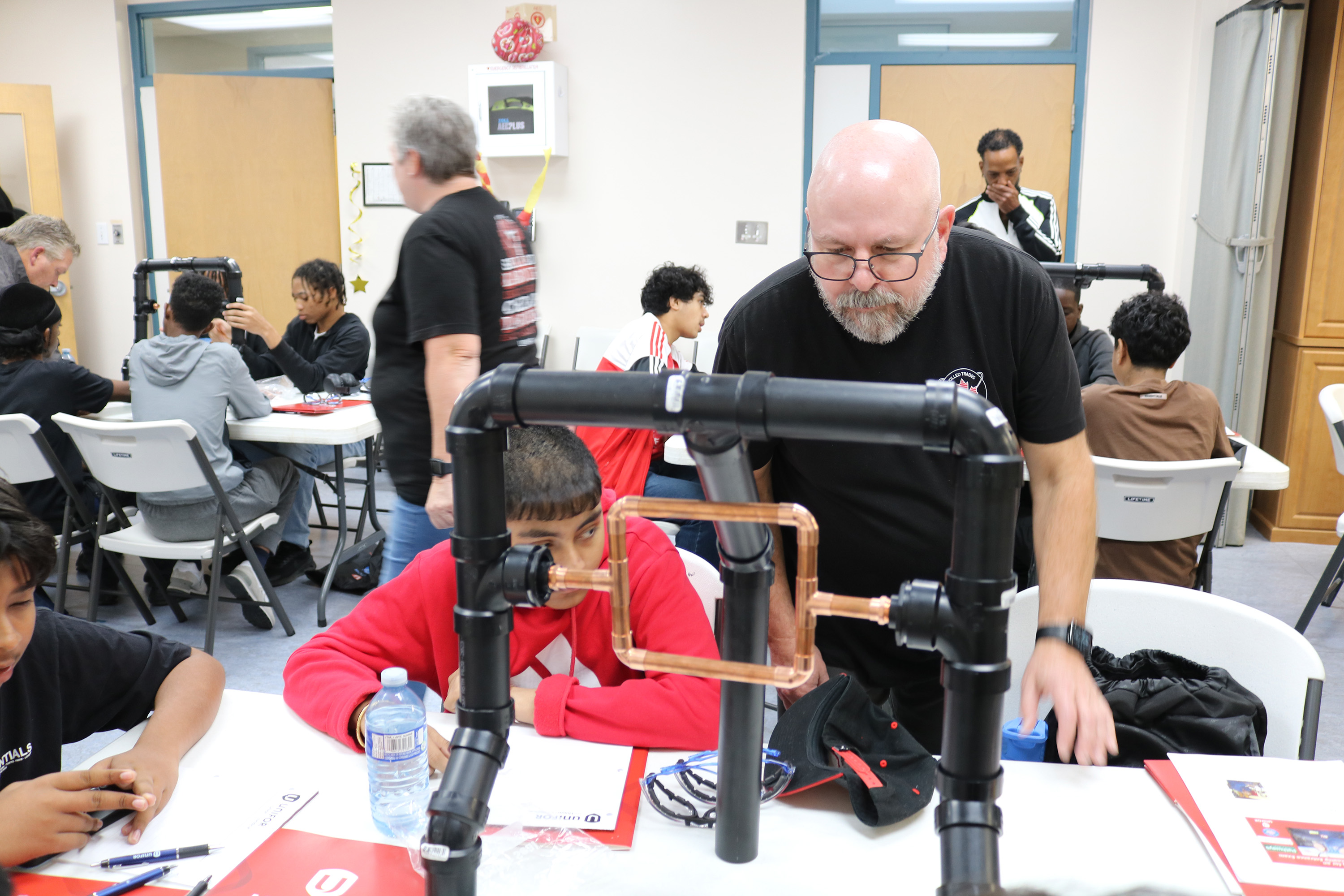 A man teaching a student on a hands on structure