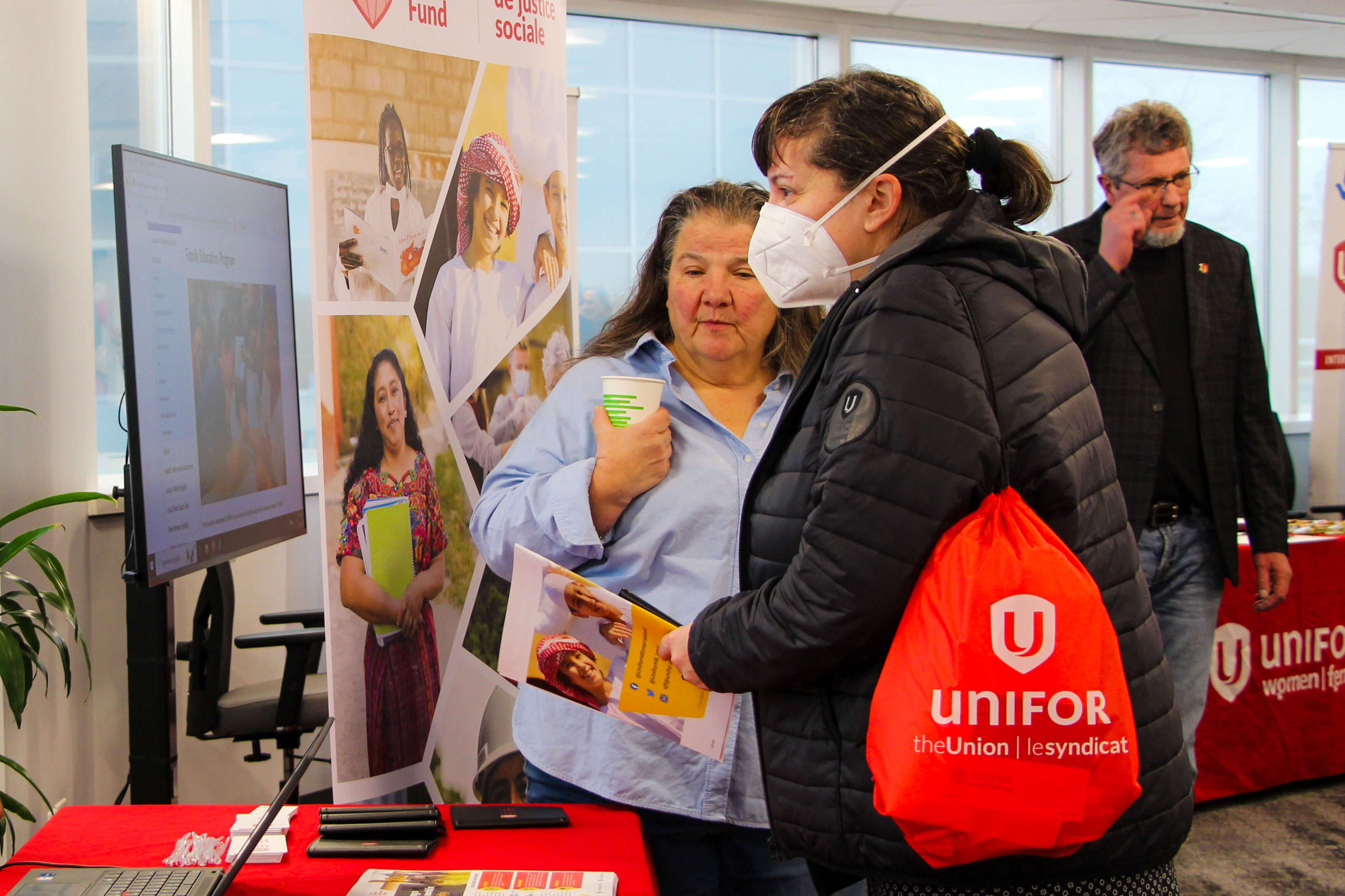 Two women talking looking at info booth 