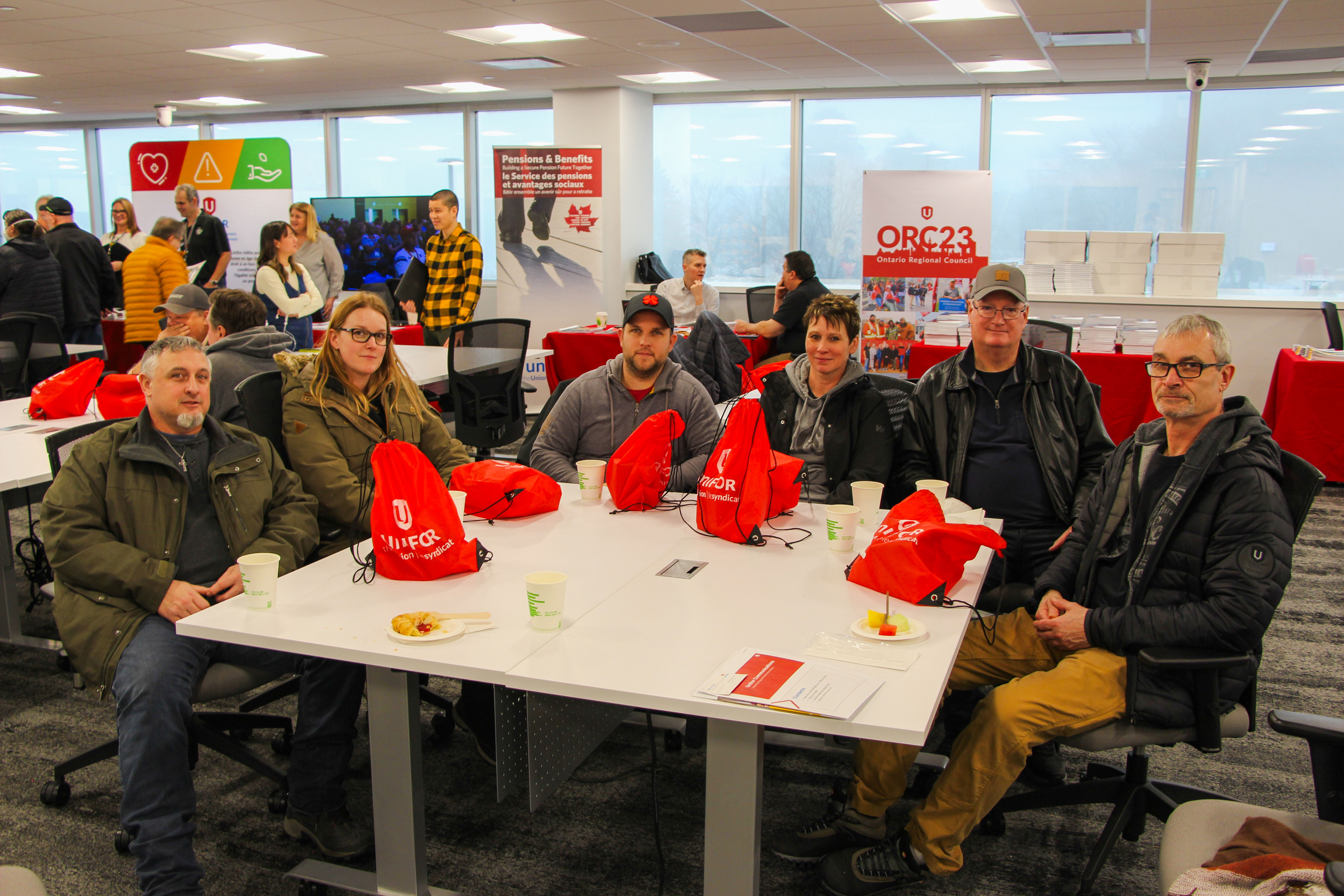 A large group sitting at tables with swag bags.