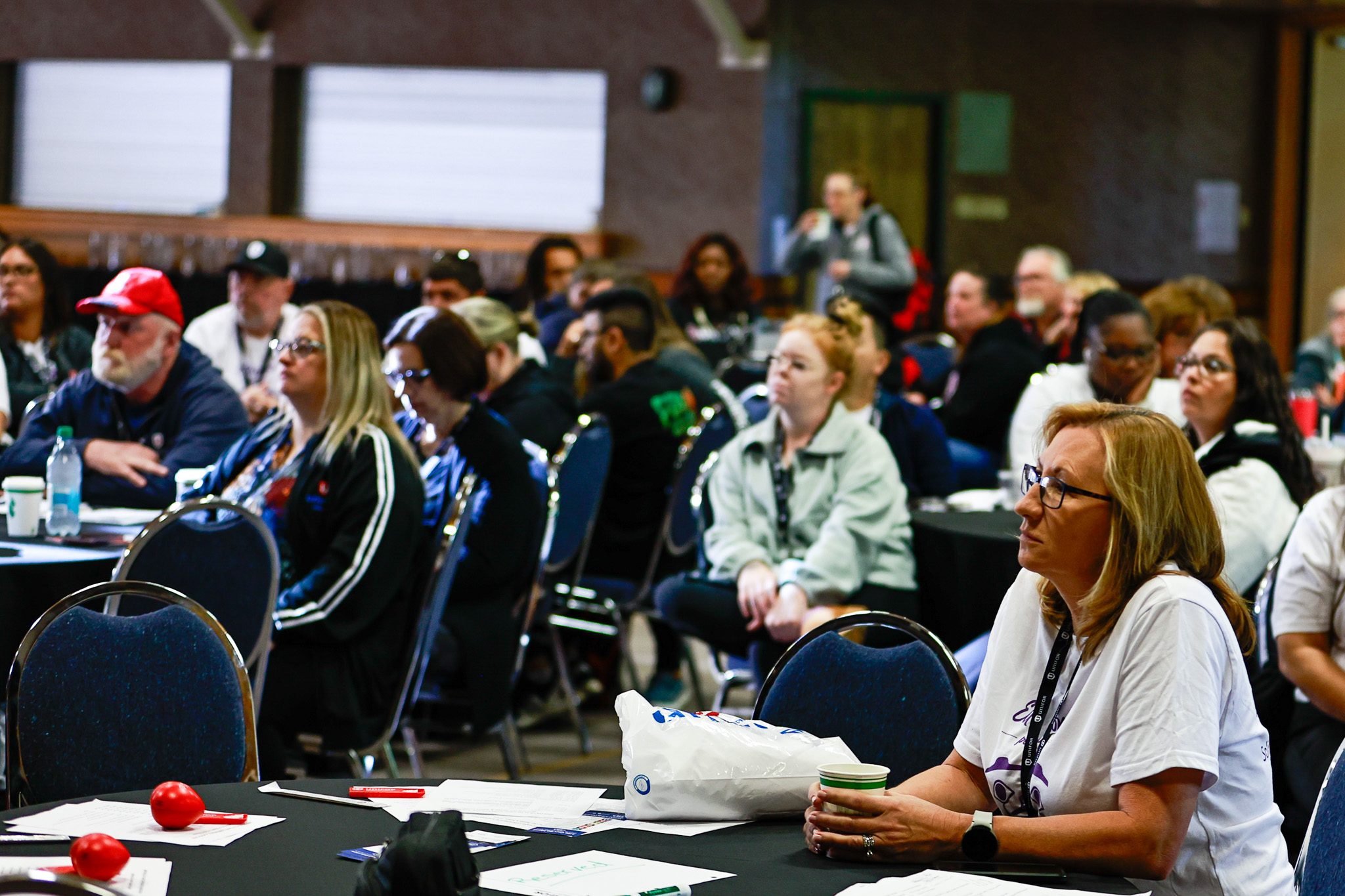 a diverse group of people sitting a round tables at a Health Care conference