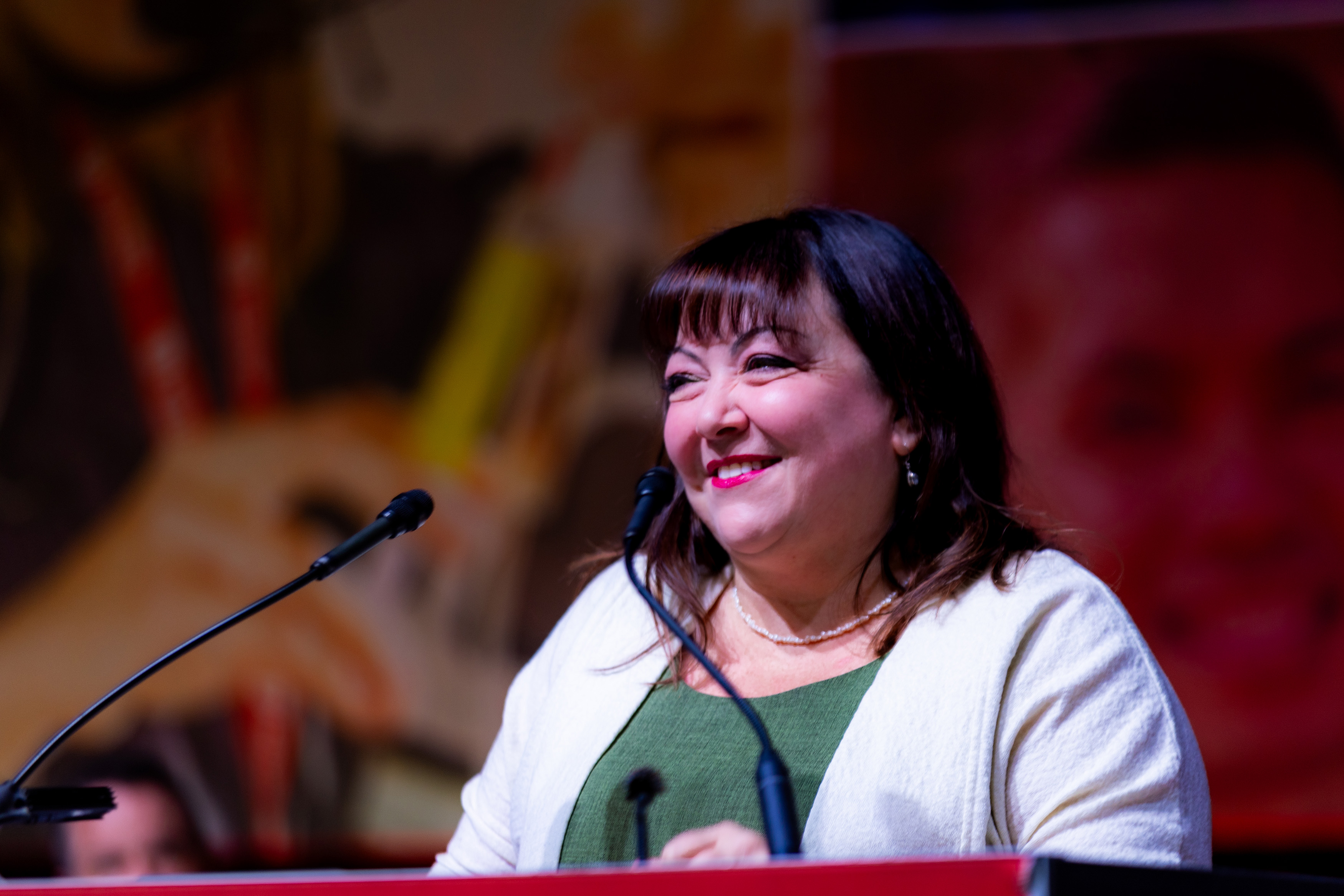 Natalie Mehra speaks at a podium.