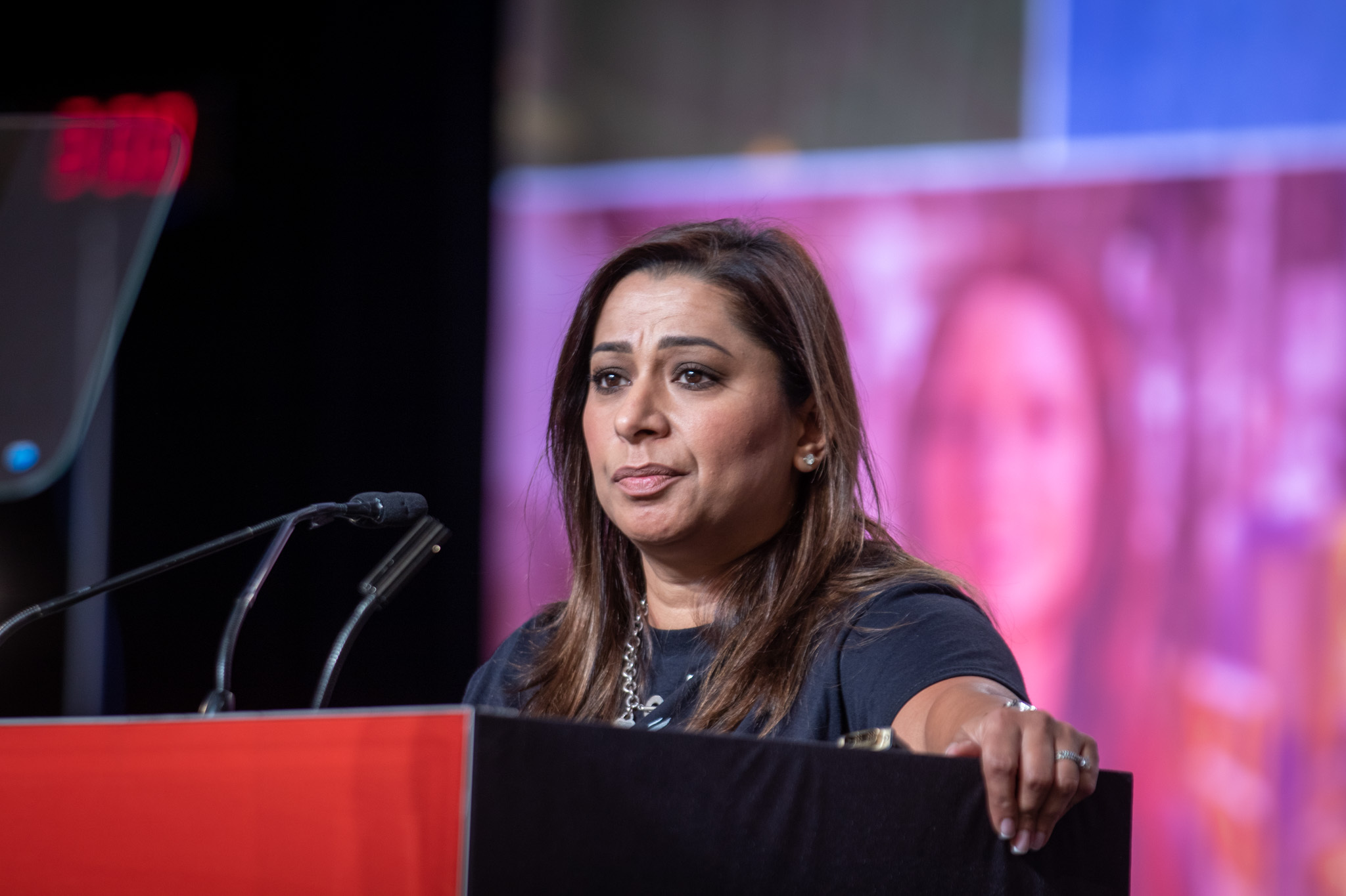 Naureen Rizvi speaking at the podium.