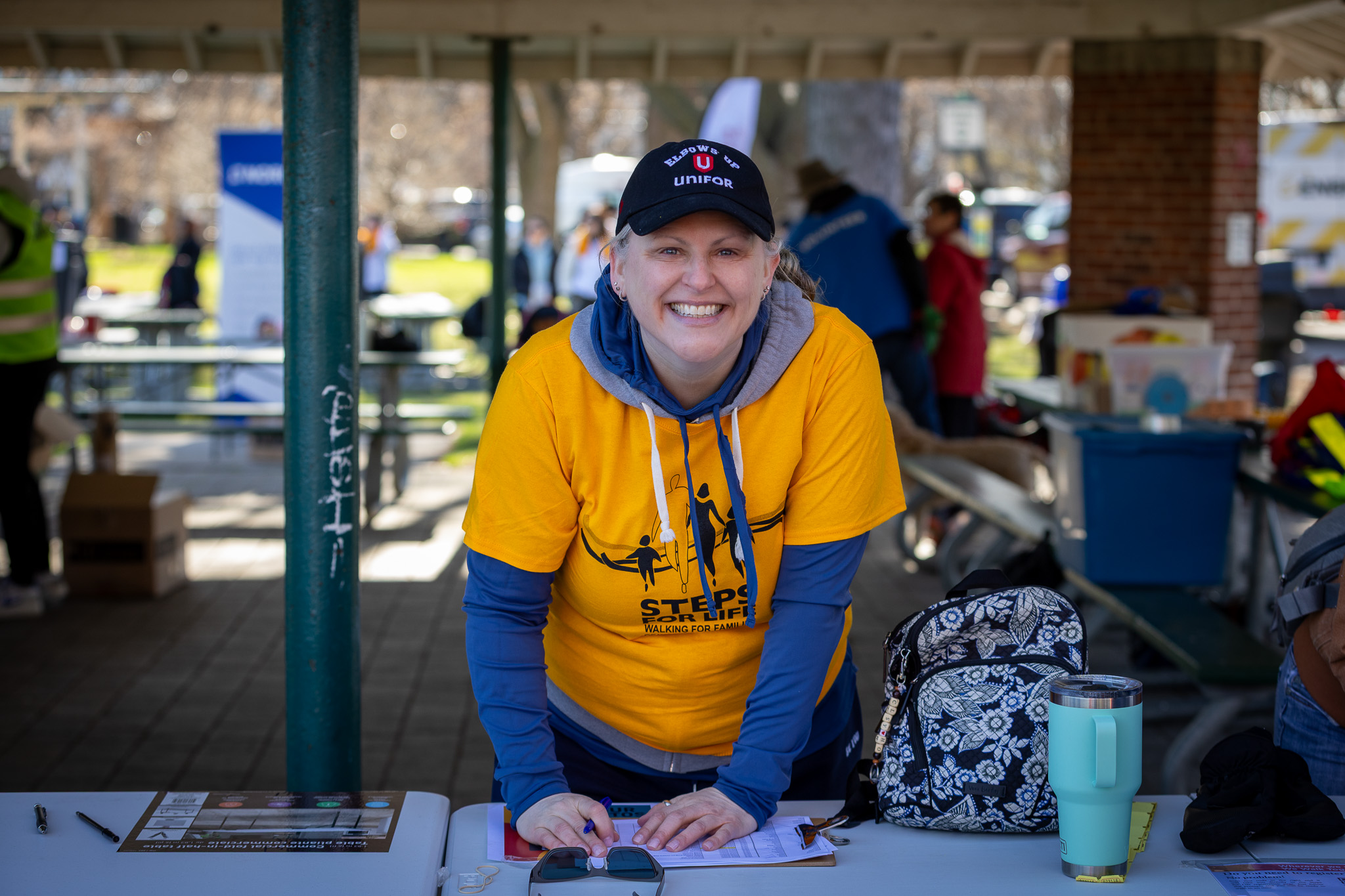A women smiling behind a table with a sign in sheet.
