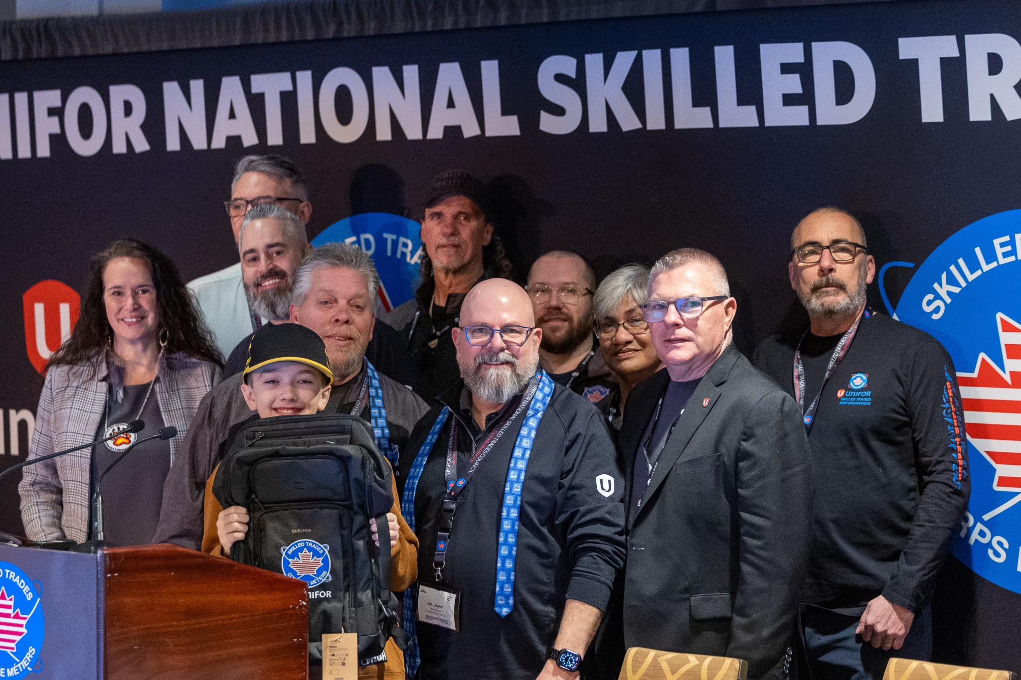 A group posing in front of a banner