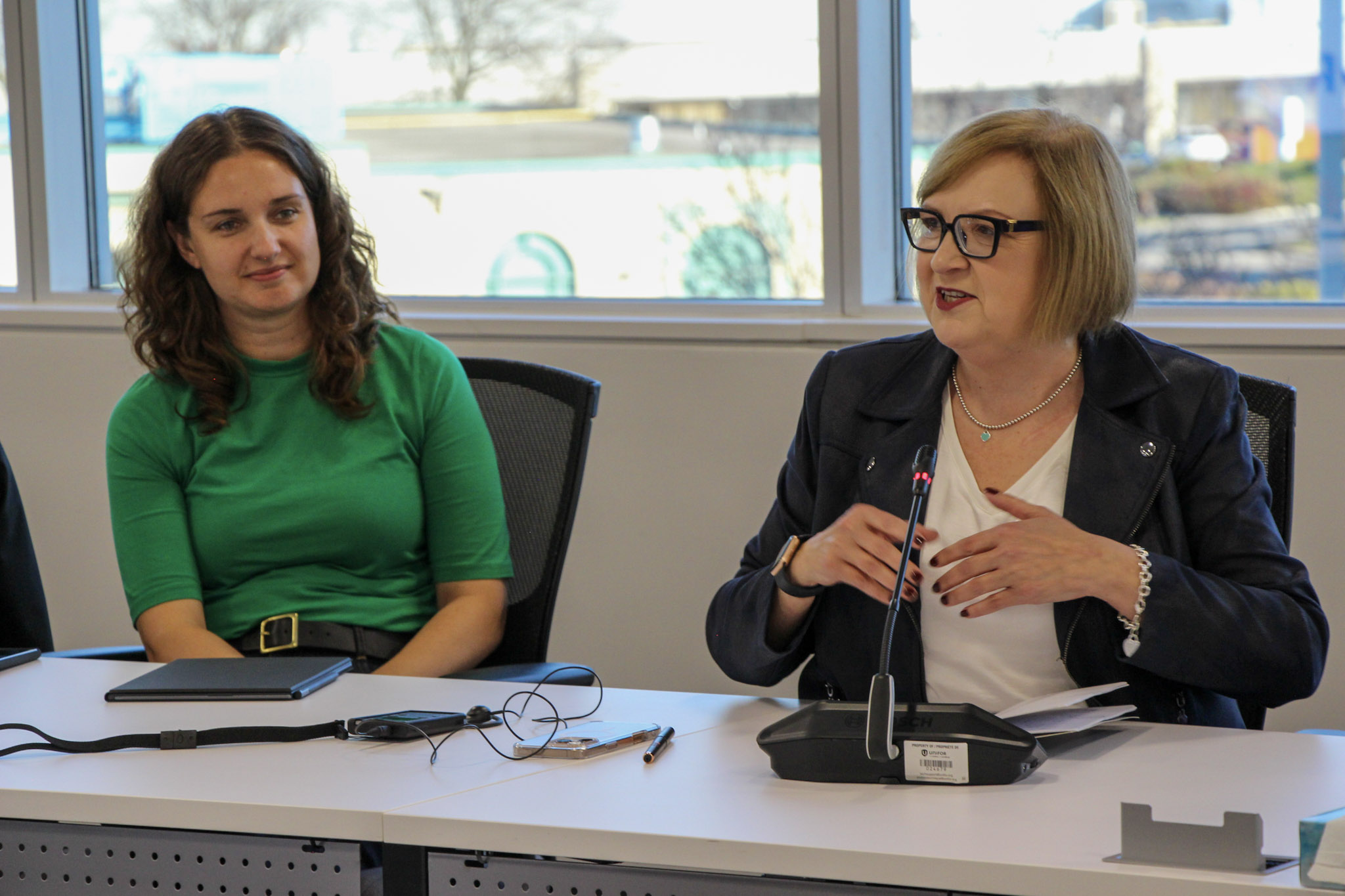 two women sitting at a desk talking