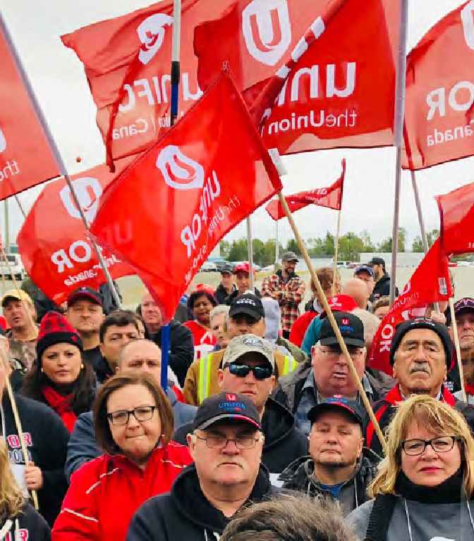 A crowd of people holding Unifor flags