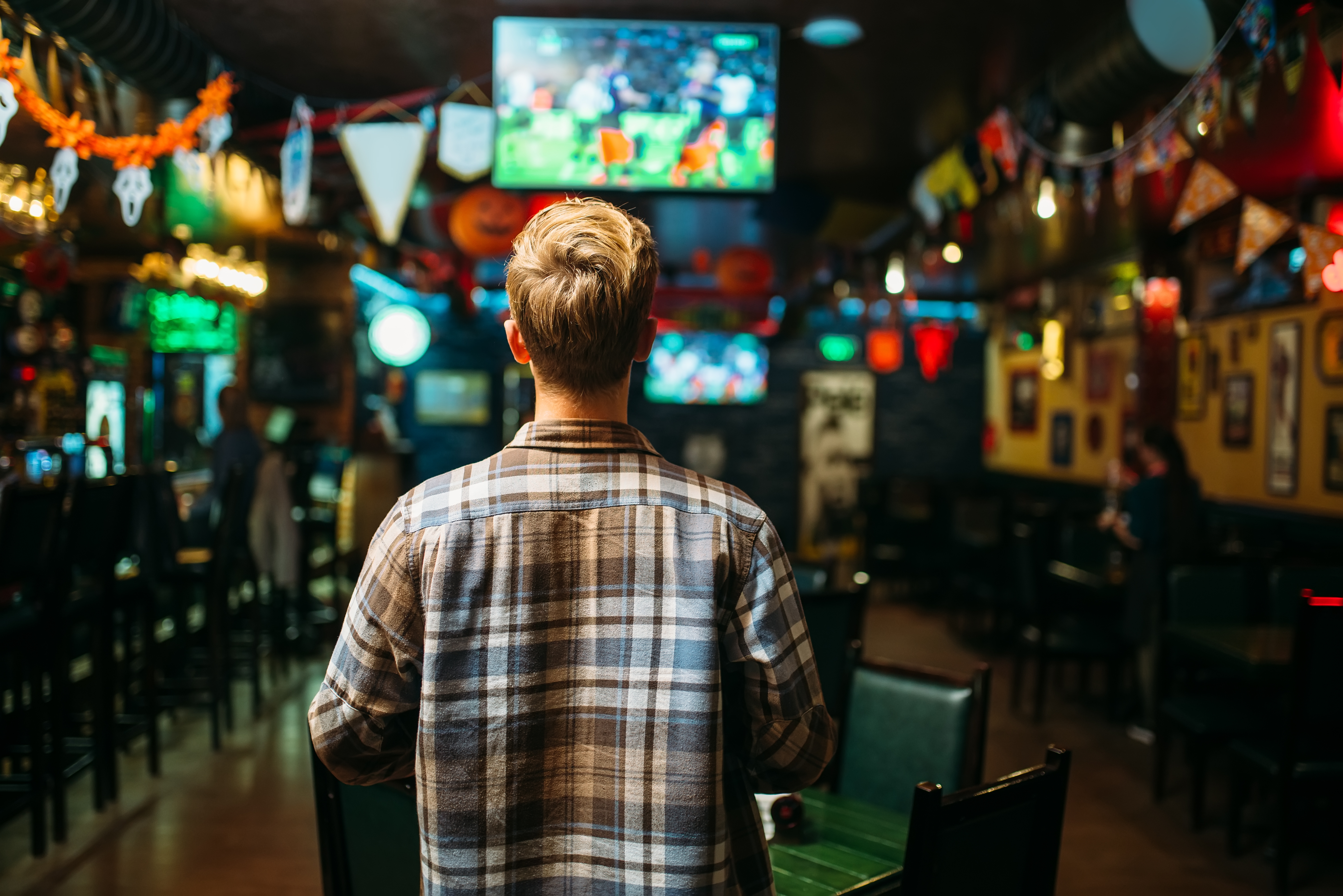 Person watching sports on a TV in a bar