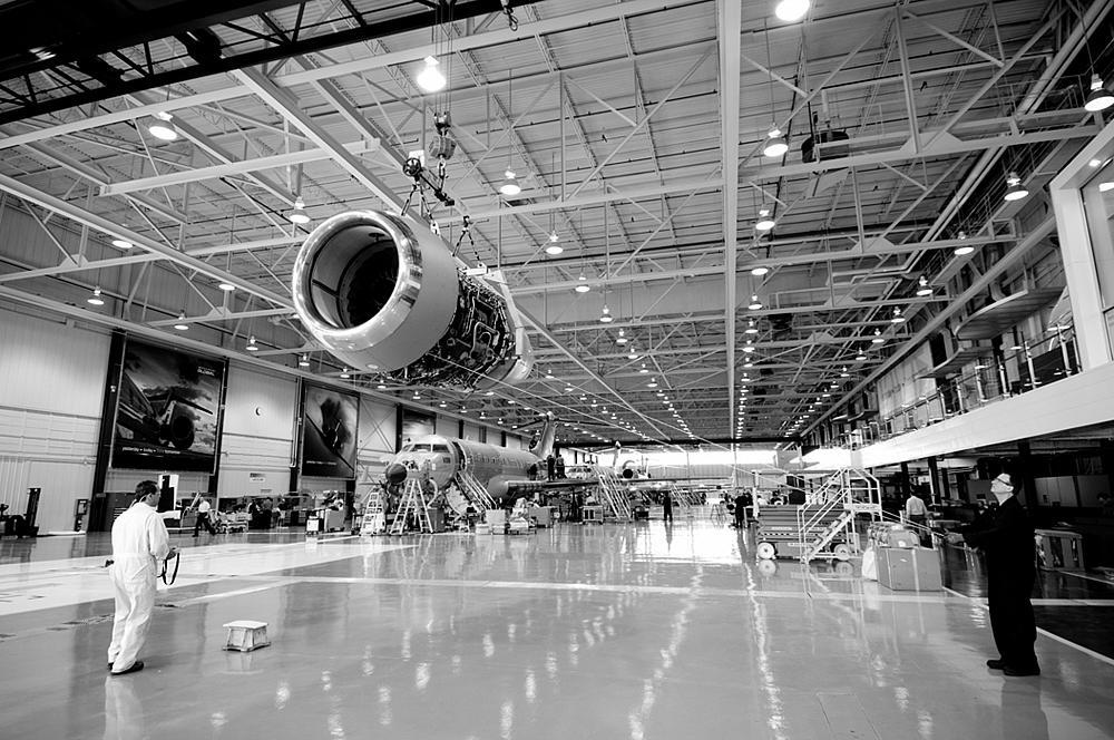 Workers at Bombardier Aerospace examine an aircraft engine nacelle