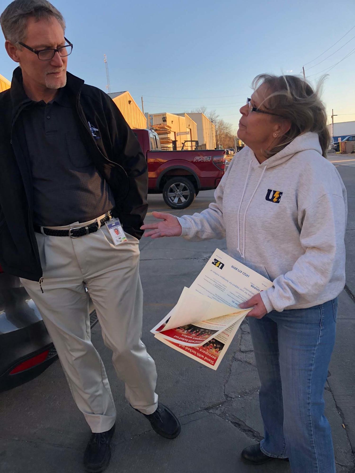 A United Electrical, Radio &amp; Machine Workers of America member hands out flyers.