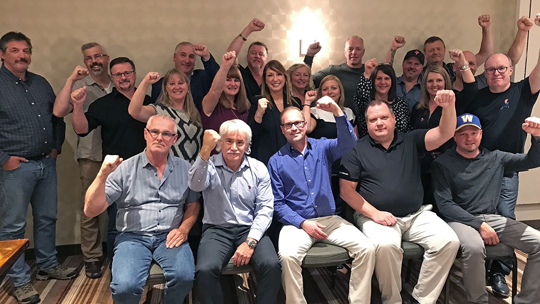 Scott Doherty et les membres d'Unifor Rail lèvent le poing en signe de solidarité.