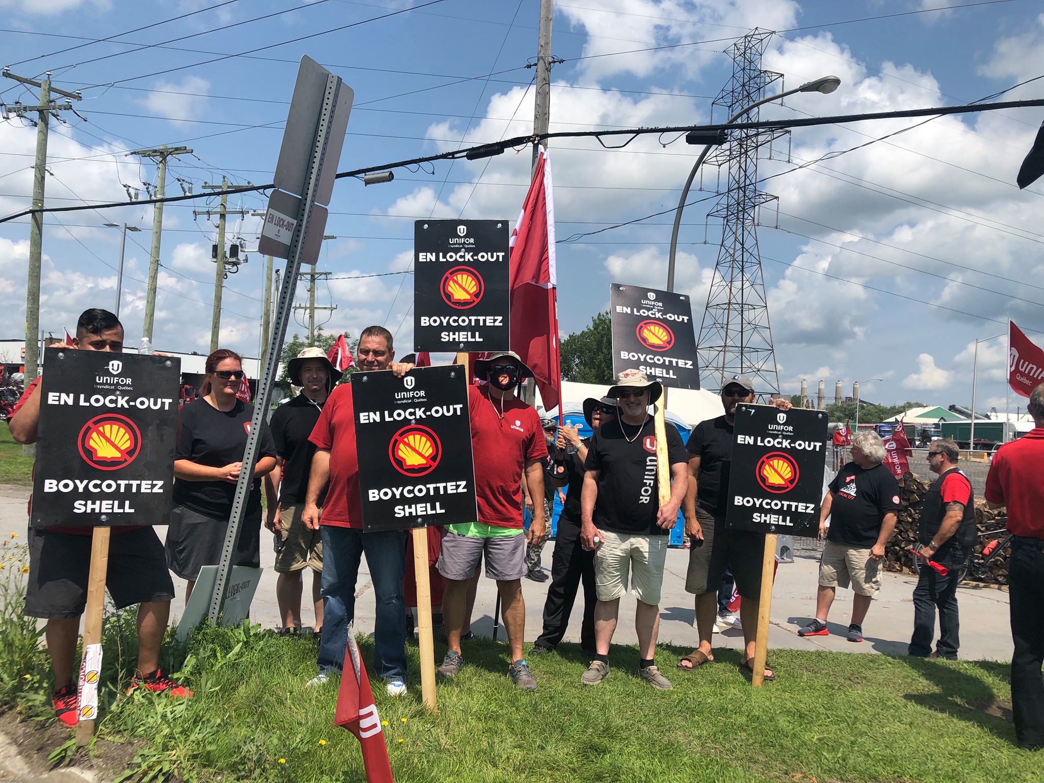 Members of Unifor Local 121 hold signs reading "Locked-out. Boycott Shell" on a picket line in Quebec.