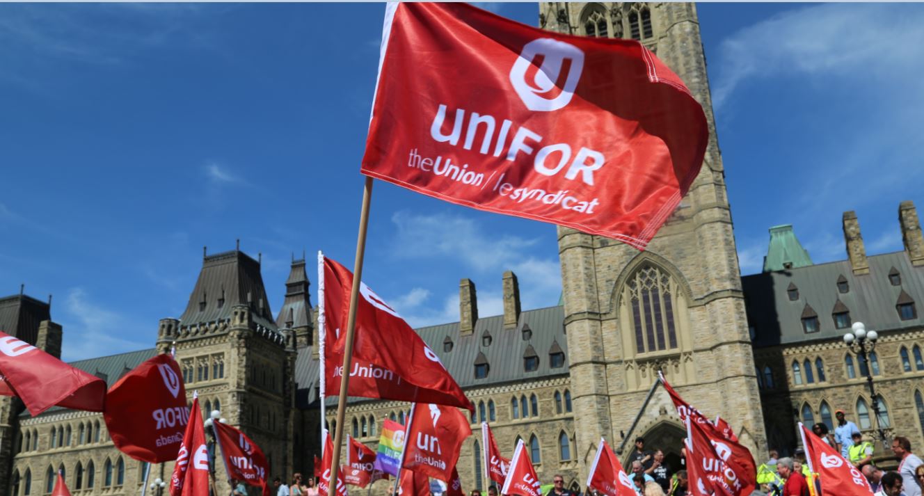 Unifor flags fly in front of the Peace Tower on Parliment Hill in Ottawa.