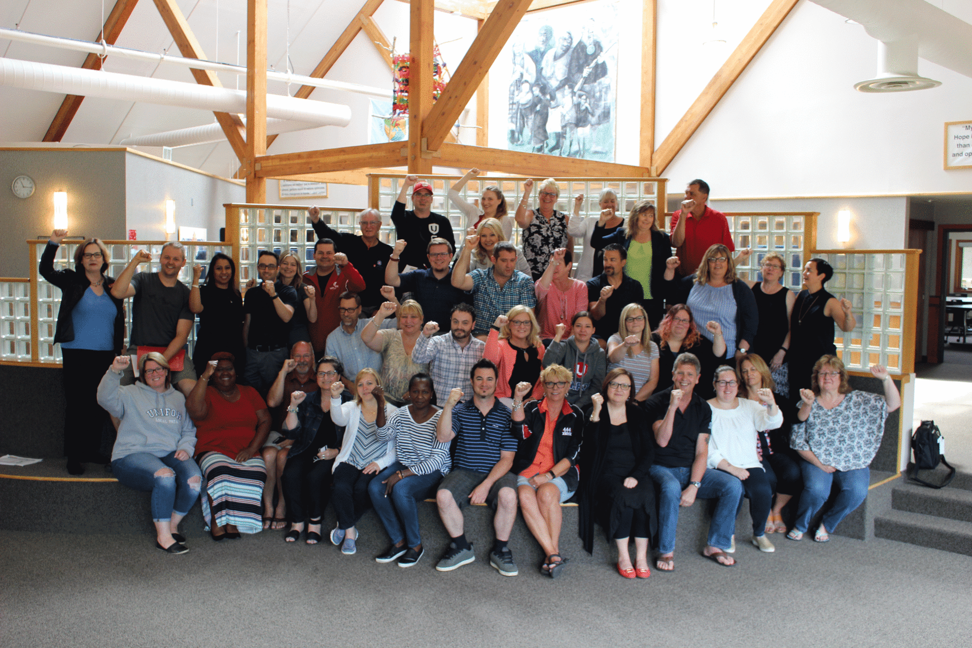 Dozens of Unifor activists at the Family Education Centre in Port Elgin raise their fists in solidarity.