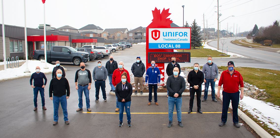 Unifor Local 88 members stand in front of their local's sign, wearing masks and respecting social distance meaures.