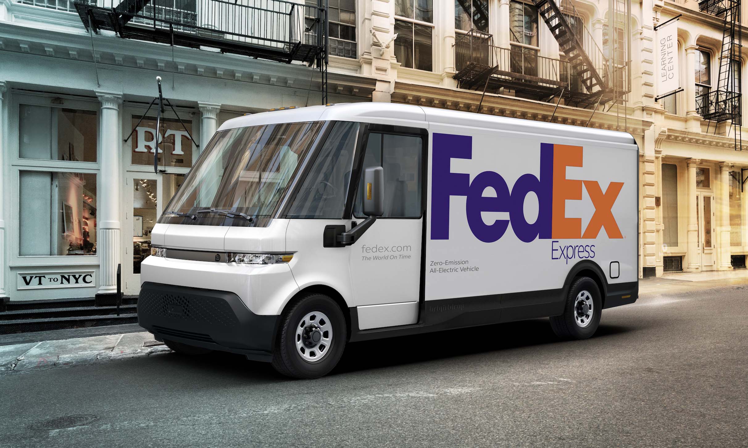 An all-electric FedEx van is parked on a city street.